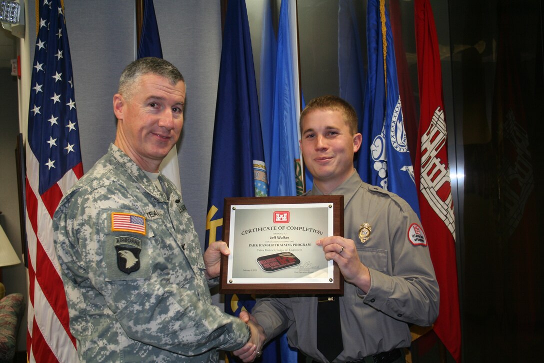 Col. Michael Teague, Tulsa District commander, presents Jeff Walker, ranger at Skiatook Lake, with his grduation certificate. Walker completed the ranger training program. 