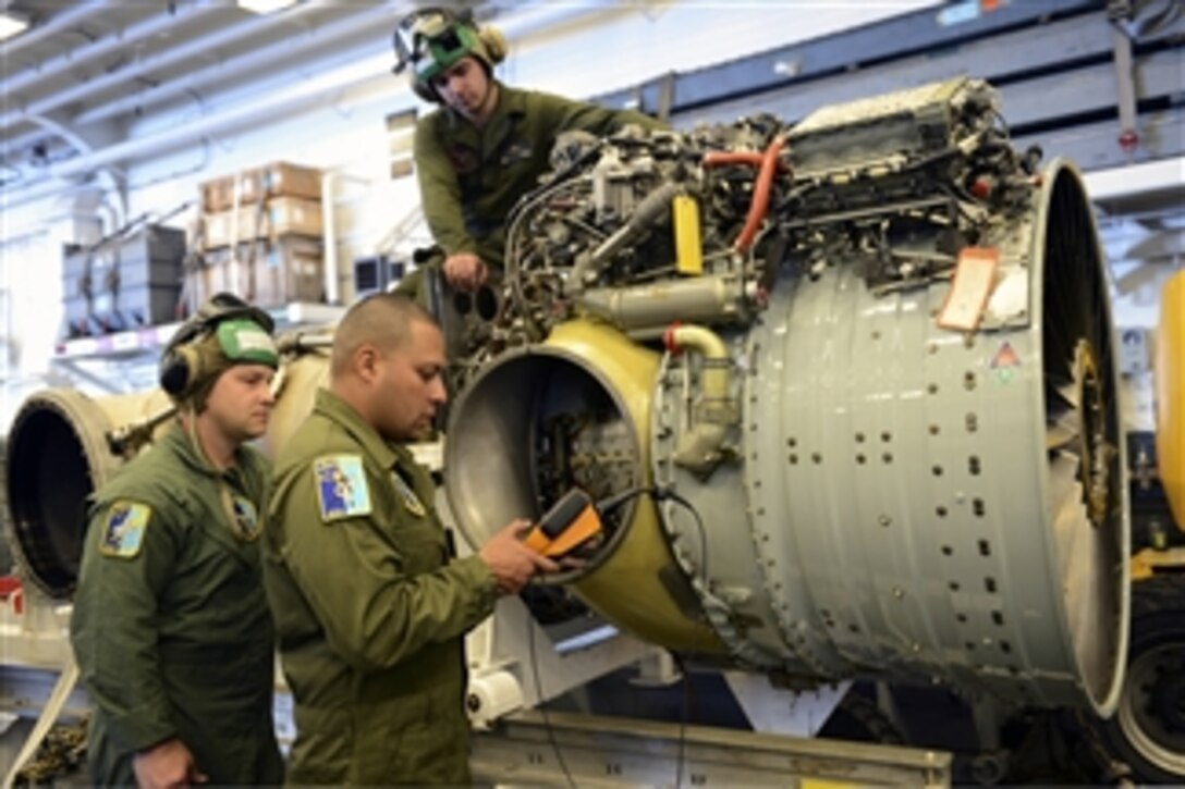U.S. Marine Corps Gunnery Sgt. Leonel Lora, right, and Staff Sgt. Steven Vladiff, left, look at the display screen of a bore scope camera to verify the engine of a AV/8 Harrier is serviceable while Cpl. Justin Powers, top, rotates the engine in the hangar bay aboard the amphibious assault ship USS Bonhomme Richard (LHD 6) on Feb. 5, 2013.  The Marines are assigned to the 31st Marine Expeditionary Unit, which is embarked as part of the Bonhomme Richard Amphibious Ready Group.  