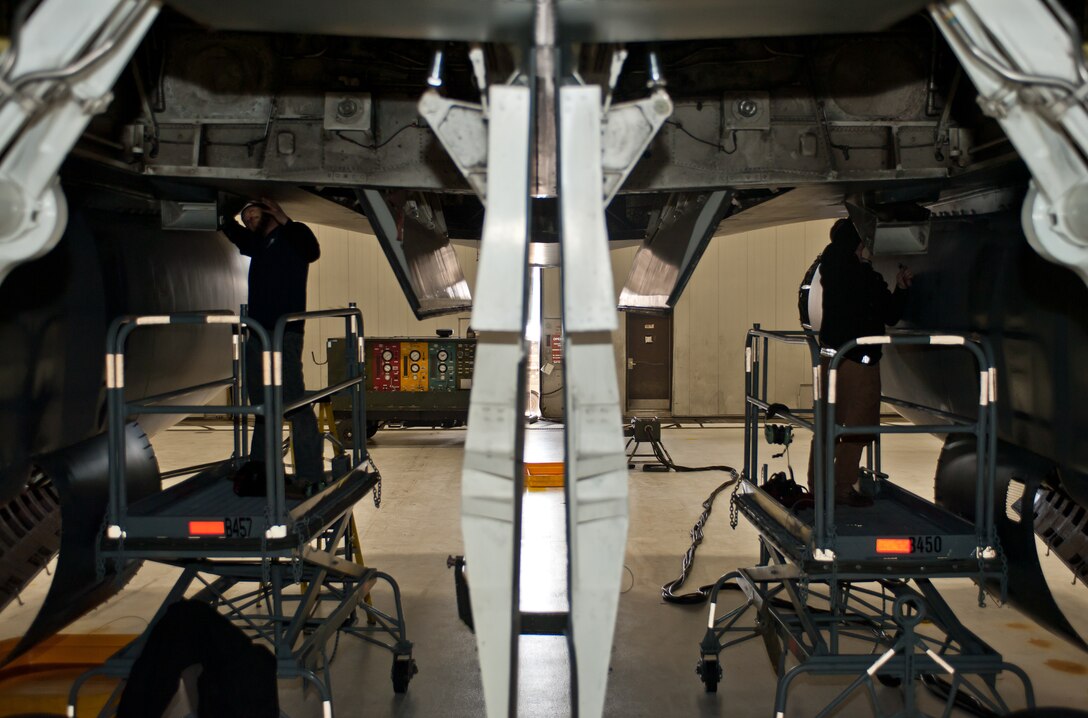 Brandon Simmons (left), 28th Aircraft Maintenance Squadron contract field team aircraft mechanic, and Derrick Brown, 28th AMXS contract field team engine mechanic, work on B-1 fuel cooling scoops during a home station maintenance check at Ellsworth Air Force Base, S.D., Jan. 22, 2013. After the fuel cooling scoops are removed, the bushings at the hinge points are replaced due to excessive wear since the last inspection. (U.S. Air Force photo by Airman 1st Class Alystria Maurer/Released)