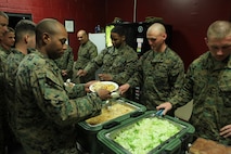 (Left) Sgt. Maj. Anthony L. Crutcher, the sergeant major of Combat Logistics Regiment 27, 2nd Marine Logistics Group, (middle) Sgt. Ryan J. Schmidt, the chief instructor of 2nd MLG’s Corporal Course, (right) Sgt. Matthew J. Stotts, an instructor for the course, serve food to the Marines graduating the four-week course during a mess night aboard Camp Lejeune, N.C., Feb. 6, 2013. During the course, noncommissioned officers with the MLG underwent a challenging physical fitness program, classroom instruction and a field exercise, where they participated in simulated engagements against their peers. 