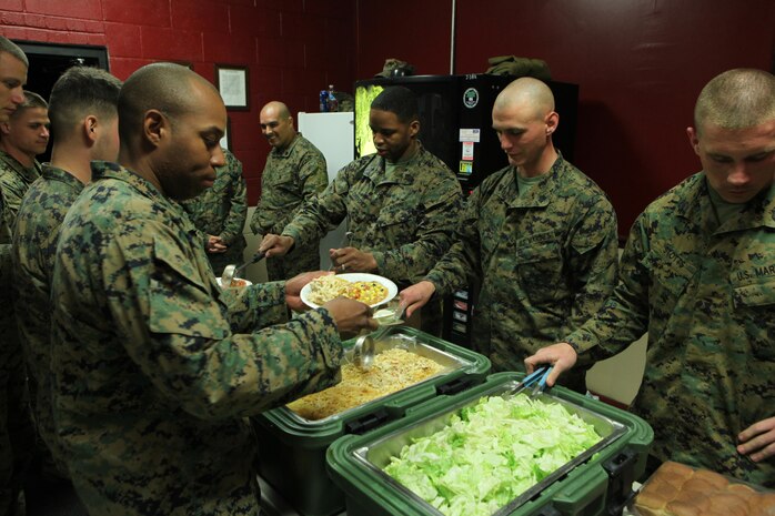 (Left) Sgt. Maj. Anthony L. Crutcher, the sergeant major of Combat Logistics Regiment 27, 2nd Marine Logistics Group, (middle) Sgt. Ryan J. Schmidt, the chief instructor of 2nd MLG’s Corporal Course, (right) Sgt. Matthew J. Stotts, an instructor for the course, serve food to the Marines graduating the four-week course during a mess night aboard Camp Lejeune, N.C., Feb. 6, 2013. During the course, noncommissioned officers with the MLG underwent a challenging physical fitness program, classroom instruction and a field exercise, where they participated in simulated engagements against their peers. 
