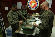(Left) Sgt. Maj. Anthony L. Crutcher, the sergeant major of Combat Logistics Regiment 27, 2nd Marine Logistics Group, serves food to Sgt. Ryan J. Schmidt, the chief instructor of the MLG’s Corporal Course, during a mess night aboard Camp Lejeune, N.C., Feb. 6, 2013. The noncommissioned officers of the MLG completed their four-week course at Camp Lejeune, where they expanded their knowledge on military tactics, protocol and leadership. 