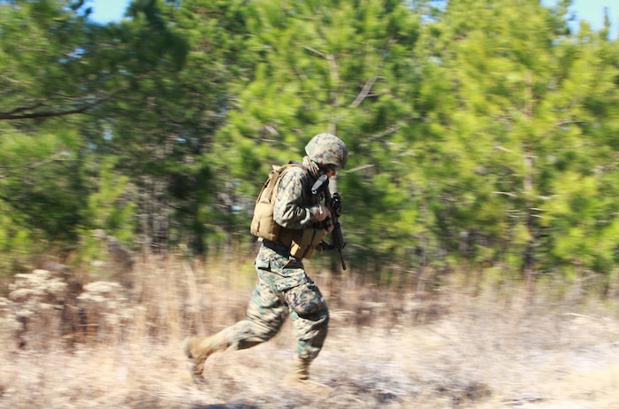 A Marine dashes across a clearing during a training exercise held by 2nd Marine Logistics Group’s Corporals Course aboard Camp Lejeune, N.C., Feb. 5, 2013. Three squads of Marines cautiously patrolled the classes training in order to practice their small-unit tactics prior to their final, graded exercise. 