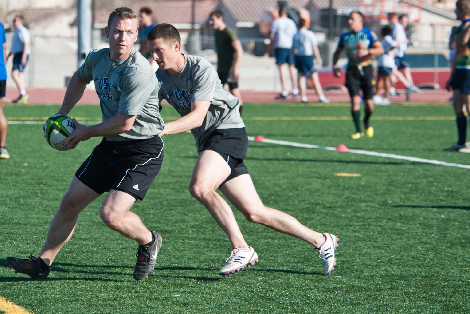 U.S. Air Force Sevens team members practice lateral passing skills during the military rugby clinic Feb. 6, 2013, held at the Warrior Fitness Center, Nellis Air Force Base, Nev. Armed forces teams participated in the rugby clinic prior to the Las Vegas Rugby Invitational Tournament.  (U.S. Air Force photo by Lawrence Crespo)