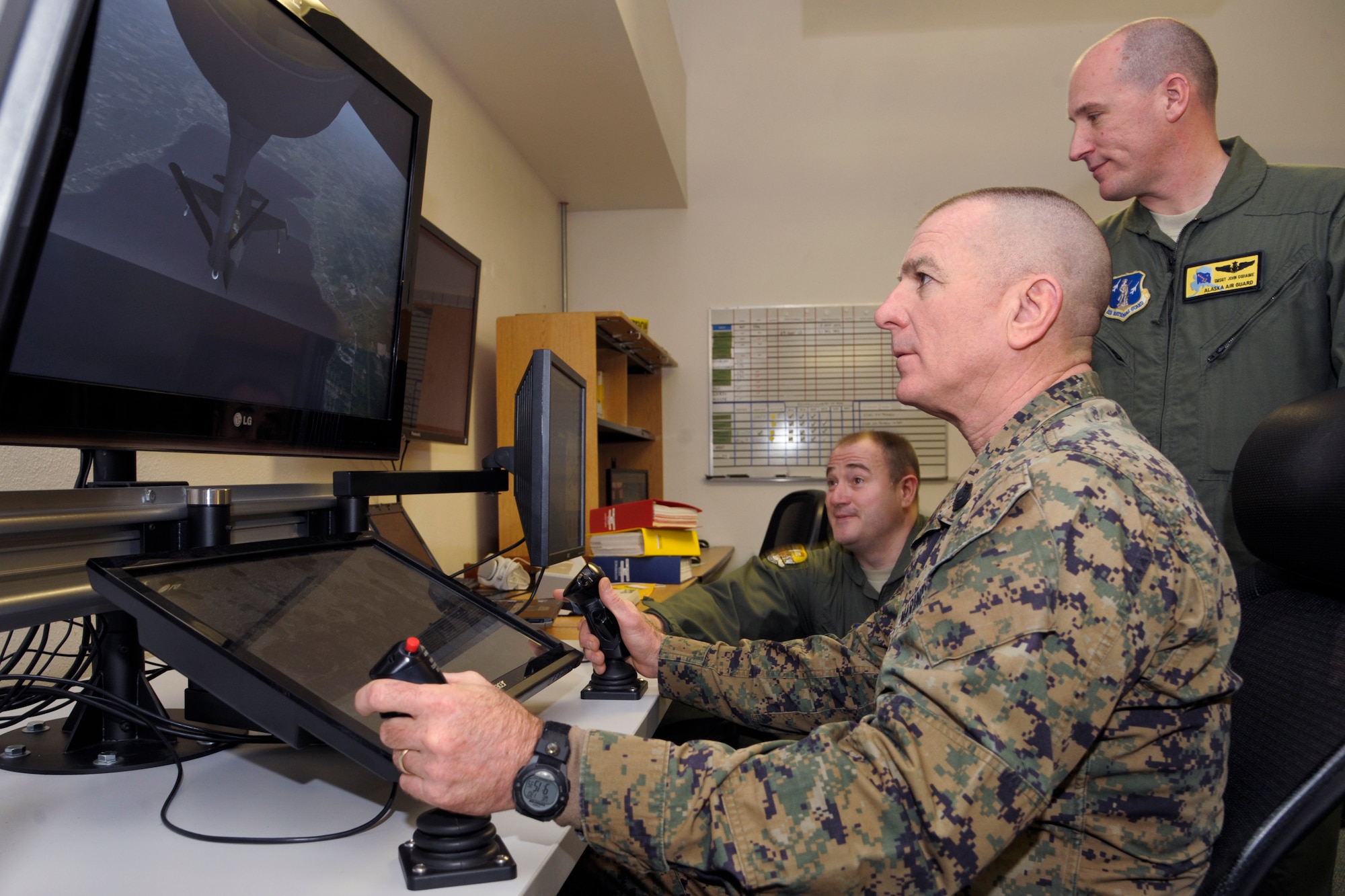 U.S. Air Force Tech. Sgt. Rich Smith, 168th Air Refueling Wing boom trainer, and Senior Master Sgt. John Duhaime, 168 ARW in-flight refueling superintendent, watch as U.S. Marine Corps Sgt. Maj. Bryan Battaglia, senior enlisted advisor to the chairman of the Joint Chiefs of Staff, tests the Micro Boom Operator Simulation System Jan. 30, 2013, Eielson Air Force Base, Alaska.  Battaglia visited the 354th Fighter Wing’s tenant wing, the 168th ARW, during a visit to Team Eielson to learn about the unique mission and operating conditions in Alaska. (U.S. Air Force Photo/Airman 1st Class Peter Reft)