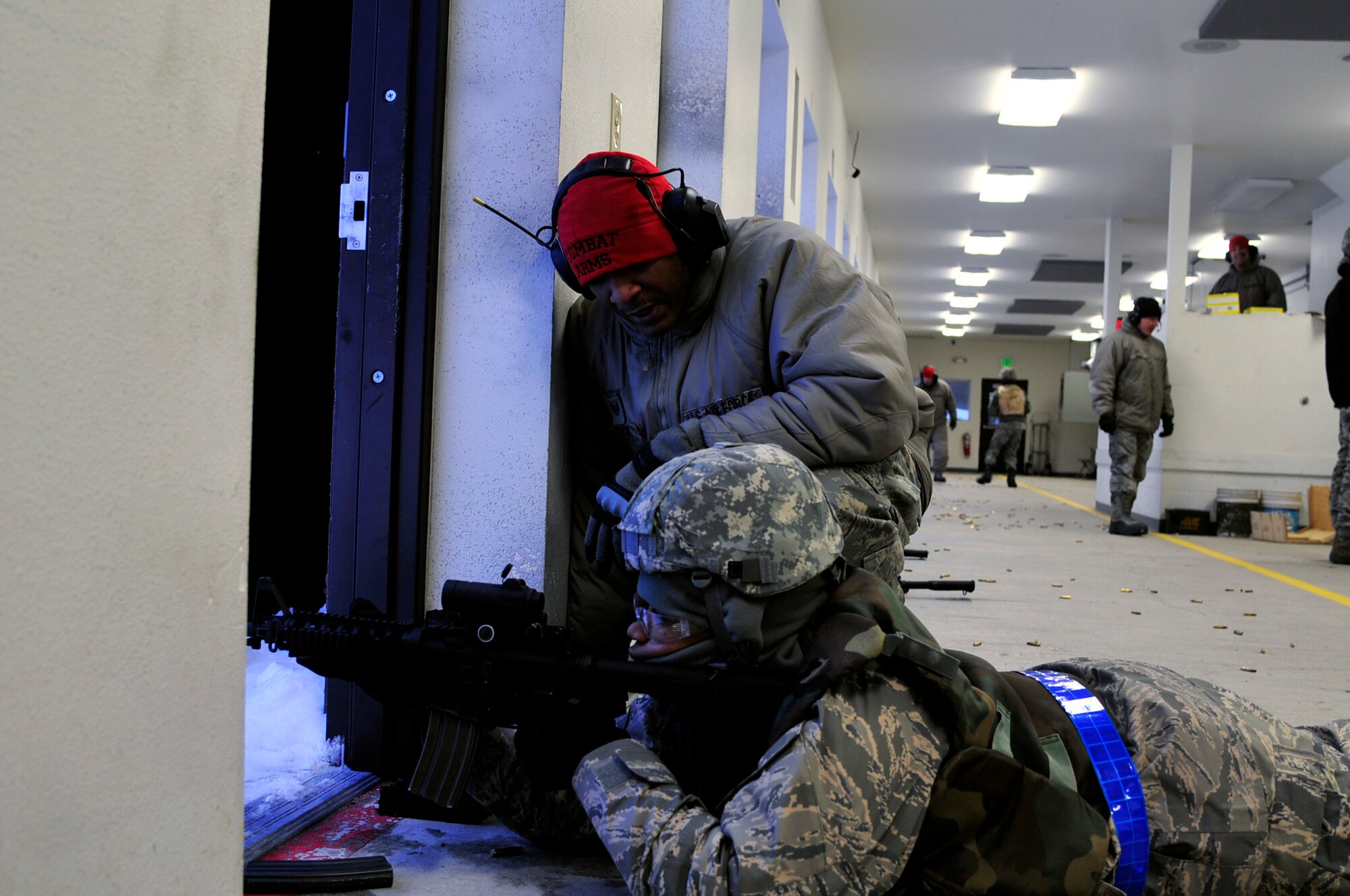 U.S. Air Force Staff Sgt. Chanson Johnson, 354th Security Forces Squadron combat arms instructor, offers a trainee helpful techniques during a live-fire session Jan. 24, 2013, Eielson Air Force Base, Alaska. Johnson advised Airmen on proper firing fundamentals as part of the SF augmentee program, helping improve mission capabilities and minimize potential base threats when additional support is needed. (U.S. Air Force photo/Senior Airman Yash Rojas)