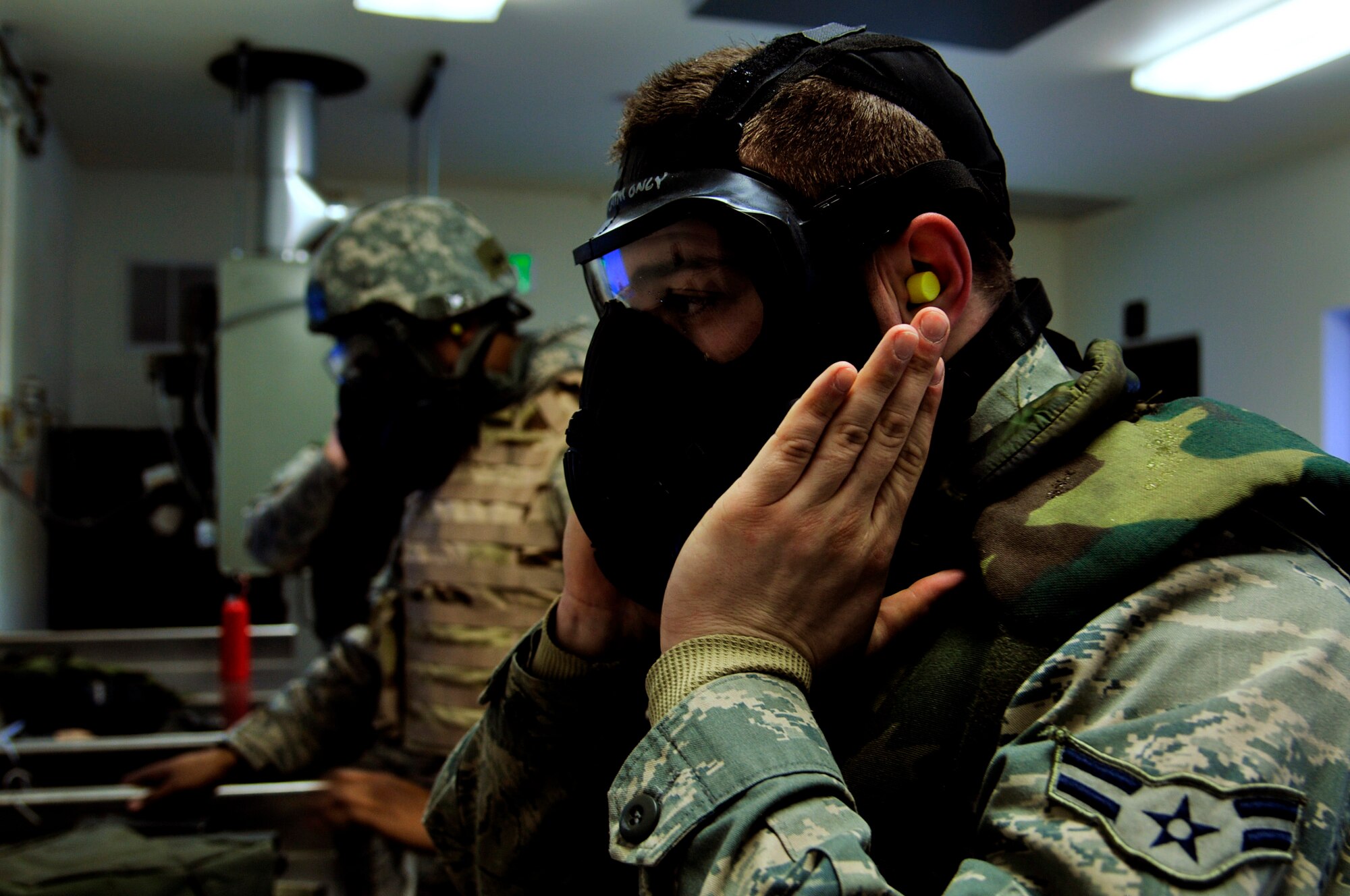 Airmen secure military gear prior to operating the M4 carbine at the Combat Arms training facility Jan. 24, 2013, Eielson Air Force Base, Alaska. Members of the Iceman team receive live-fire training as part of the 354th Security Forces Squadron augmentee training, making them combat ready in the event of future threats. (U.S. Air Force photo/Senior Airman Yash Rojas)