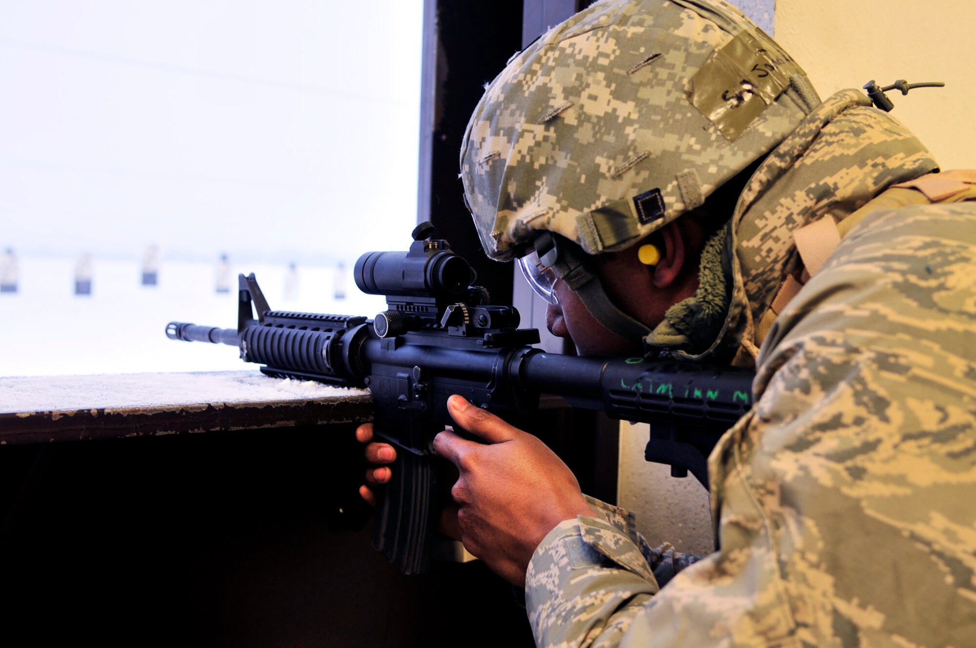 An Airman aims an M4 carbine down range during the Combat Arms session of Security Forces augmentee training Jan. 24, 2013, Eielson Air Force Base, Alaska. Before trainees can become official 354th Security Forces Squadron augmentees, Icemen must be fully qualified to operate the M4 to later serve as supplemental members of the 354th SFS. (U.S. Air Force photo/Senior Airman Yash Rojas)