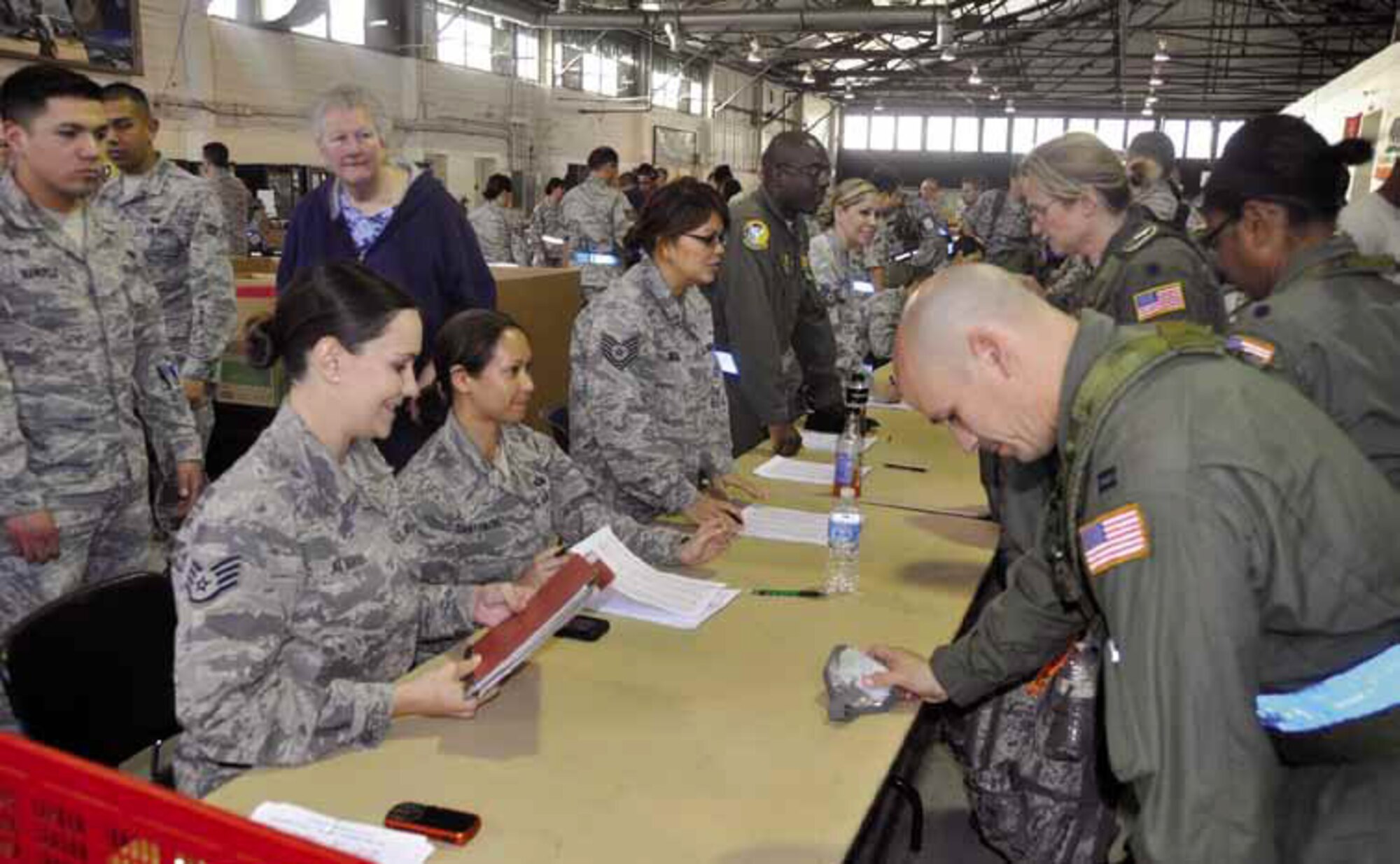 452d Force Support Squadron personnel, (from left to right) Staff Sgt. Megan Alvarado, Master Sgt. Tiffany Santamaria, along with Tech. Sgt. Alene Yath, 452d Maintenance Squadron and Master Sgt. Rick Fowler, 729th Airlift Squadron receive returning March Airmen from the Operational Readiness Inspection held in Gulfport, Miss., Feb 1. (U.S. Air Force photo by Darnell Gardner)