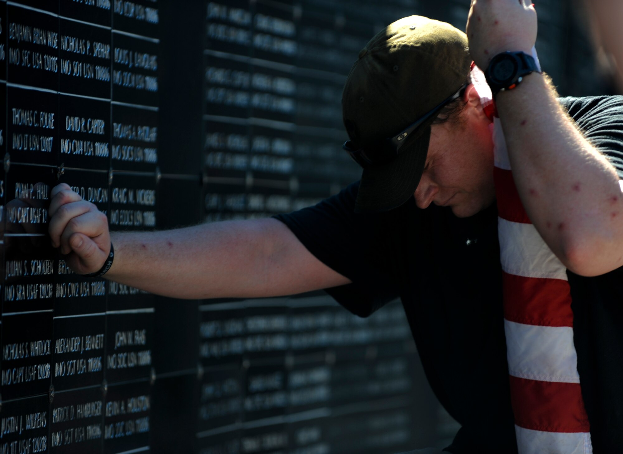 Maj. Mitchell Sherman, 1st Special Operations Wing Air Commando, mourns the loss of fallen heroes at the U.S. Special Operations Command memorial wall at MacDill Air Force Base Fla., Feb. 8, 2013. Sherman and fifteen other members of the Air Commandos took part in a  450-mile fallen hero rememberance ruck-march that  began on the Emerald Gulf Coast and ended at MacDill AFB. (U.S. Air Force photo by Staff Sgt. Brandon Shapiro/Released)