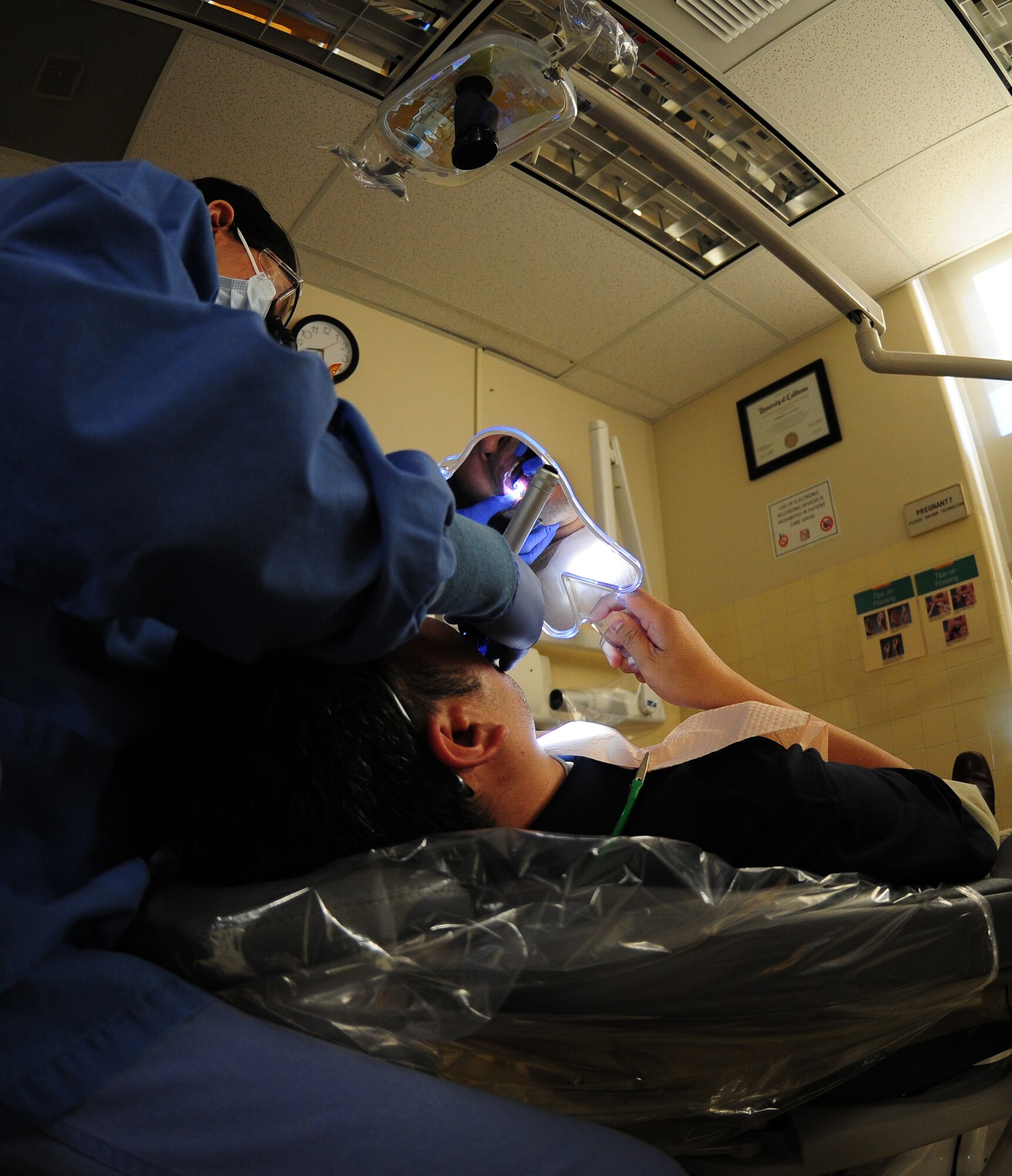 Capt. Kimberly Quilao, 9th Aerospace Medical Dental Squadron general dentist, uses a transilluminator to check for cracks in a patient's teeth at the dental clinic on Beale Air Force Base Calif., Feb. 8, 2013. Cracked tooth syndrome is a dental condition in which a partial crack extends into the dentin. (U.S. Air Force photo by Senior Airman Allen Pollard/Released)
