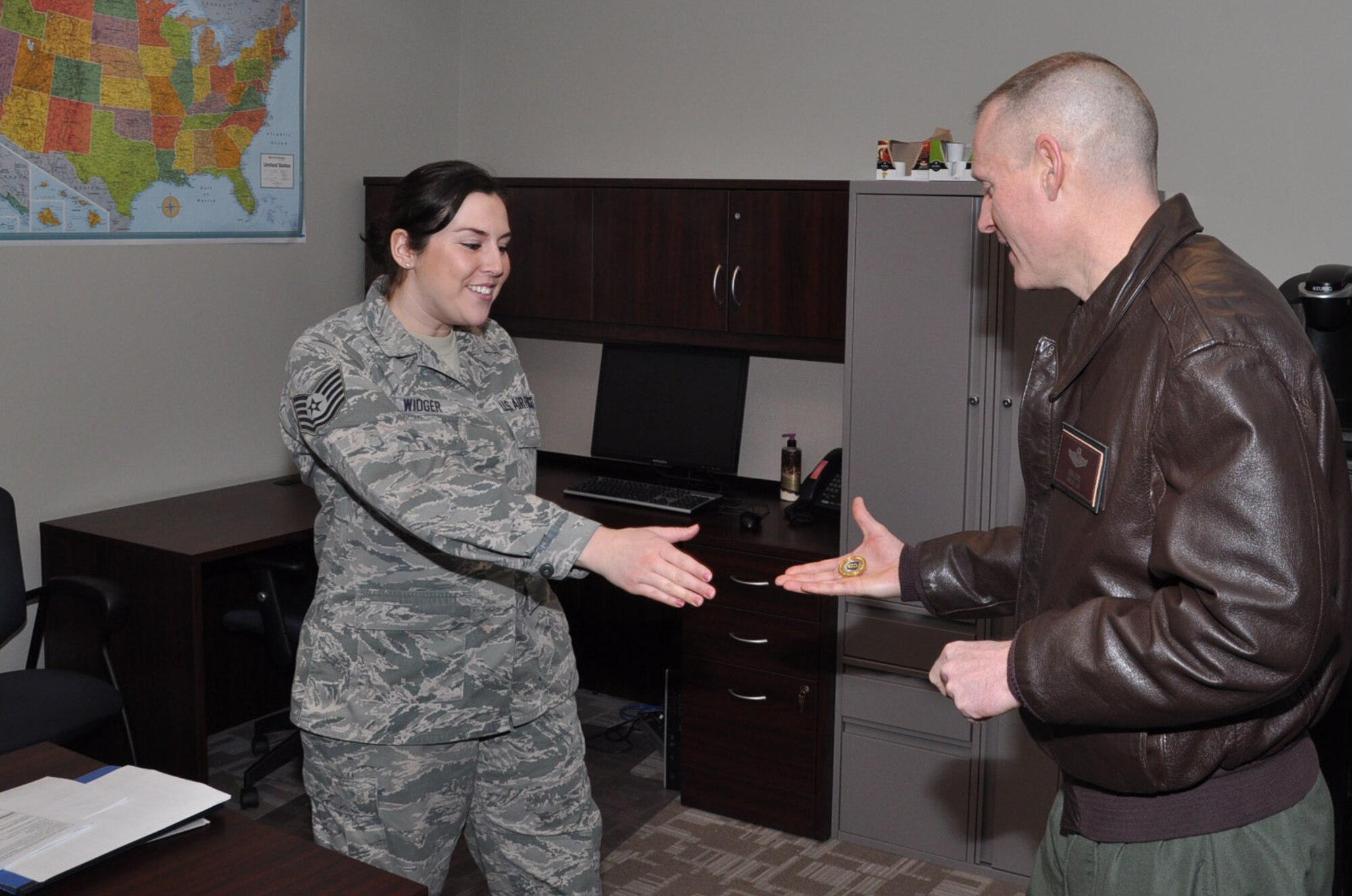 Brig. Gen. Kenneth D. Lewis,Director, Air Force Reserve Plans, Programs and Requirements, presents a coin to Tech. Sgt. Katie Widger, 931st Maintenance Operations Flight, for superior performance Feb. 8. Lewis visited the 931st Air Refueling Group and met with Airmen in their work places. (Air Force photo by Brannen Parrish)