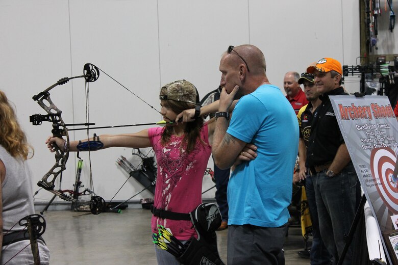 Air Force Global Strike Command Chief Master Sgt. Brian Hornback gives advice as his daughter practices an archery shot. The father-daughter team began archery as a way to spend more time with each other. (Courtesy photo)
