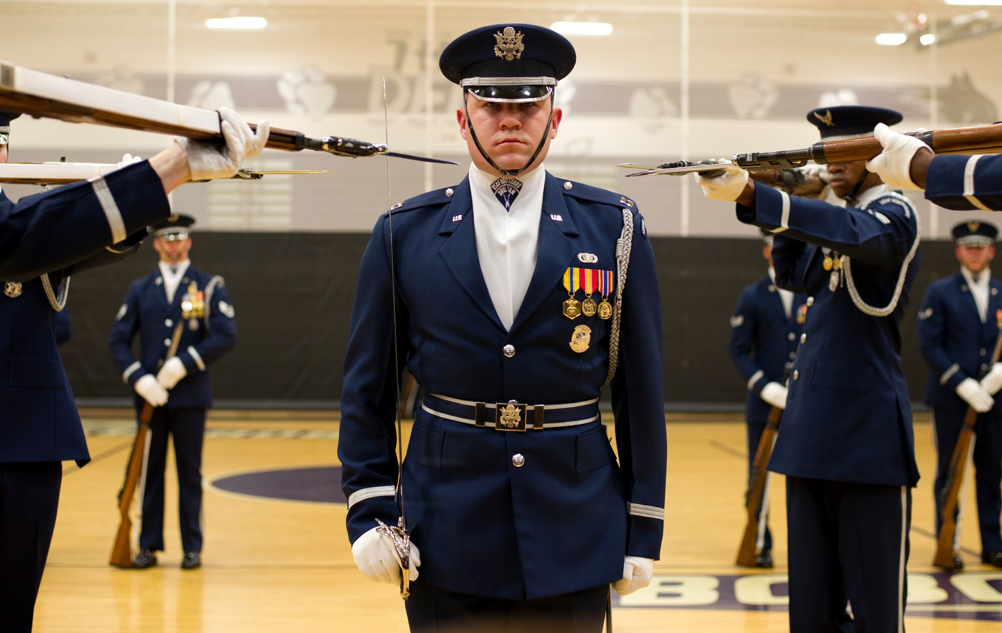 Capt. Alexander Stanton, U.S. Air Force Honor Guard Drill Team commander, stands at attention as four drill team members point their bayonets toward him during a performance Feb. 6, 2013 at Battlefield High School in Haymarket, Va. The performance was Stanton’s final performance with the Drill Team. (U.S. Air Force photo/ Senior Airman Bahja Joi Jones)