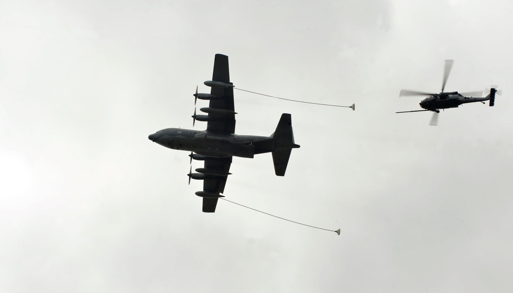 An HC-130P Combat King and an HH-60G Pave Hawk conduct in-flight refueling during a combat search and rescue demonstration at Moody Air Force Base, Ga., Feb. 7, 2013. Various media outlets witnessed training from a combination of squadrons from the 347th Rescue Group. (U.S. Air Force photo by Airman 1st Class Olivia Bumpers/Released)