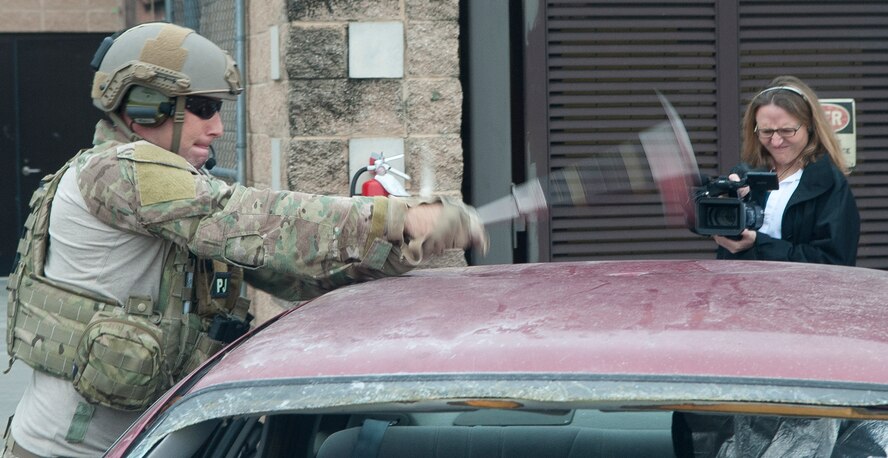 U.S. Air Force Senior Airman Jason Fishman, 38th Rescue Squadron guardian angel team member, uses an axe to puncture holes in a car roof during a breach and rescue demonstration at Moody Air Force Base, Ga., Feb. 7, 2013. The 38th RQS allowed media to document and participate in the demonstration to understand what it takes to get a trapped person out of a vehicle. (U.S. Air Force Photo by Airman Paul Francis/Released)
