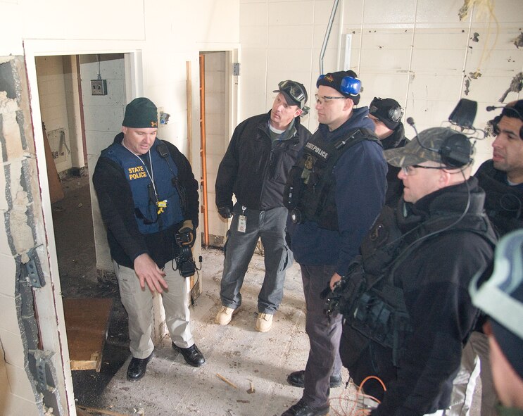 Sgt. Chris Ennis, left, Delaware State Police Explosive Ordnance Disposal team commander reviews the effectiveness of a training blast with EOD team members from the Delaware and New Jersey State Police along with Air Force teamm members (not shown) during a training event at Dover Air Force base, Del. on Feb. 7, 2013. The training allowed the State Police and Air Force EOD teams to gain valuable training using live explosives during simulated events that mirror recent real-world scenarios encountered by EOD teams across the nation. The civilian law enforcement and USAF teams exchanged ideas and best practices in the hands-on training to ensure all are safe and well prepared for the future. (U.S. Air Force photo/Greg L. Davis)   