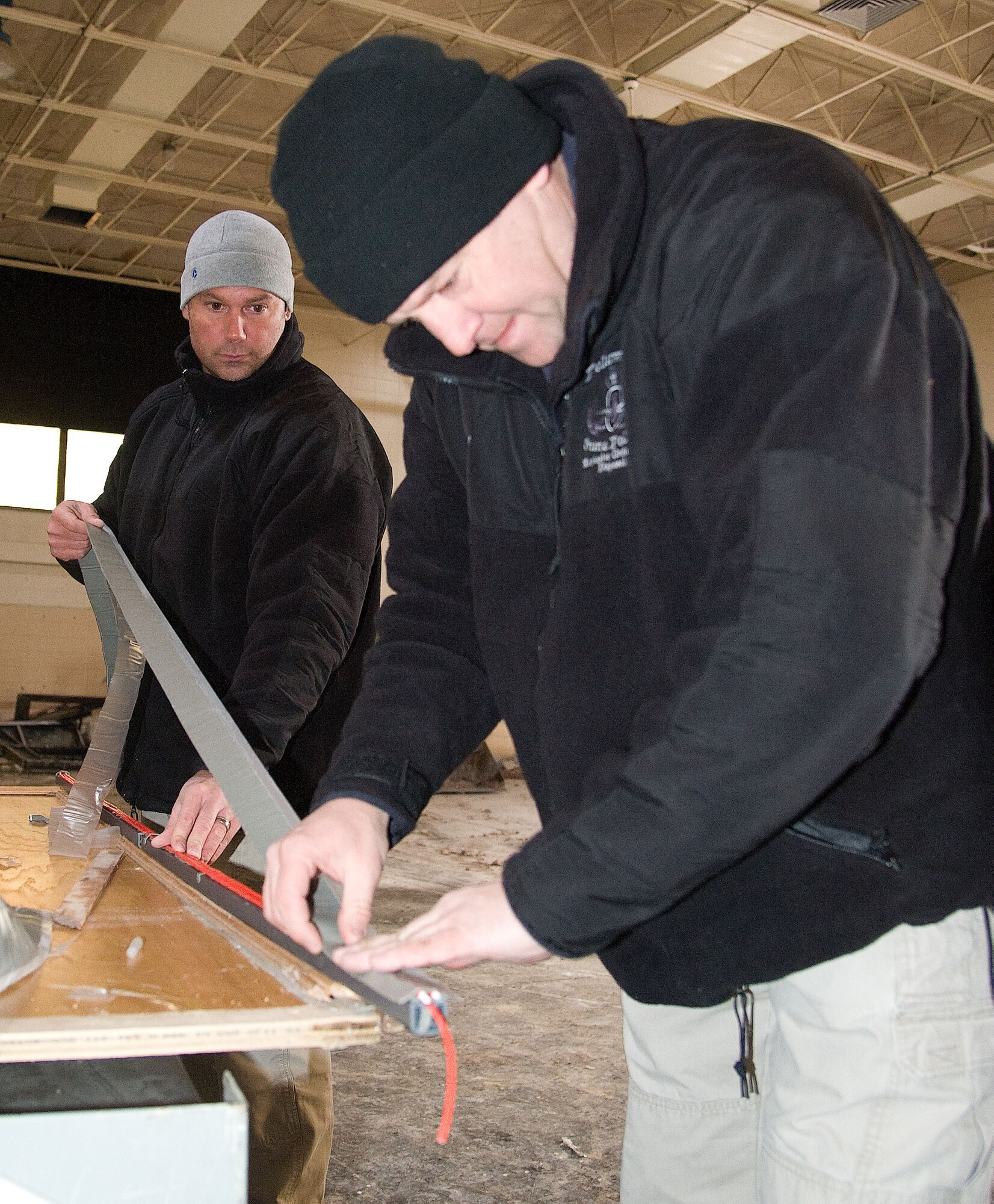 Sergeant's Chris Ennis (foreground) and Frank Fuscellaro of the Delaware State Police prepare a strip of explosives inside the former Arnold Elementary School on Dover Air Force Base, Del. on Feb. 7, 2013. Ennis is the DSP Explosive Ordnance Disposal (EOD) team commander while Fuscellaro is part of the DSP Governor's Task Force. Members of the 436th Civil Engineer Squadron conducted an Exposive Ordnance Disposal (EOD) training event at Dover Air Force base, Del. on Feb. 7, 2013. The training allowed the Air Force EOD team to gain valuable training using live explosives during simulated events that mirror recent real-world scenarios encountered by EOD teams across the nation. The 436th CE Squadron also hosted regional law enforcement teams from the Delaware and New Jersey State Police. The civilian law enforcement and USAF teams exchanged ideas and best practices in the hands-on training to ensure all are safe and well prepared for the future. USAF photo/Greg L. Davis   