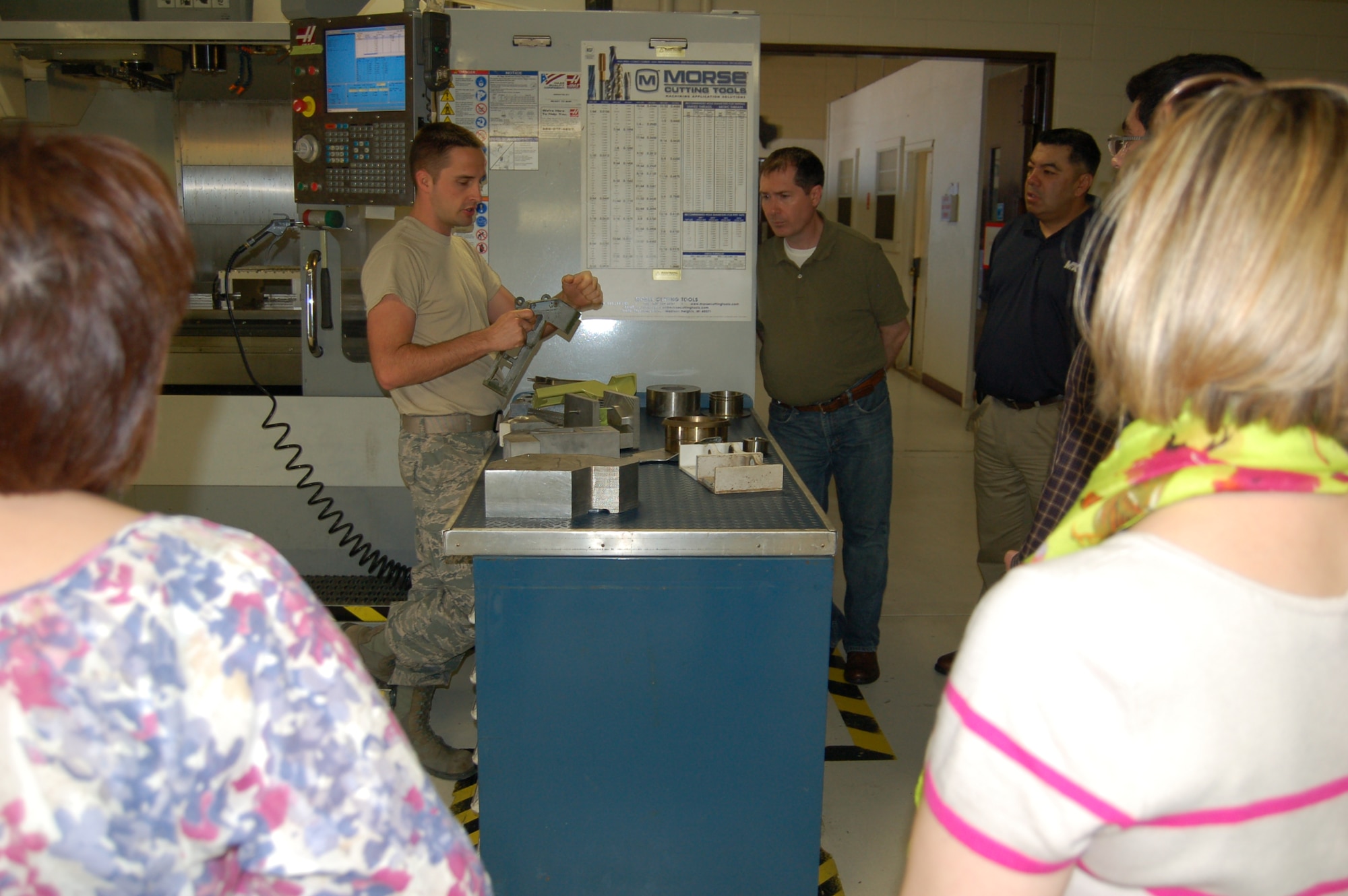 Staff Sgt. Steve Morris, a metals technician with the 433rd Airlift Wing's Metals Technology Shop, demonstrates the shop's computer numerical control mill center, which manufactures components for the C-5A Galaxy that have long since become unavailable.  Demonstration was done for visitors from insurance giant USAA, who visited the M-TECH shop and other sites to learn about the missions performed by the 433rd Airlift Wing. (U.S. Air Force photo by Elsa Martinez)