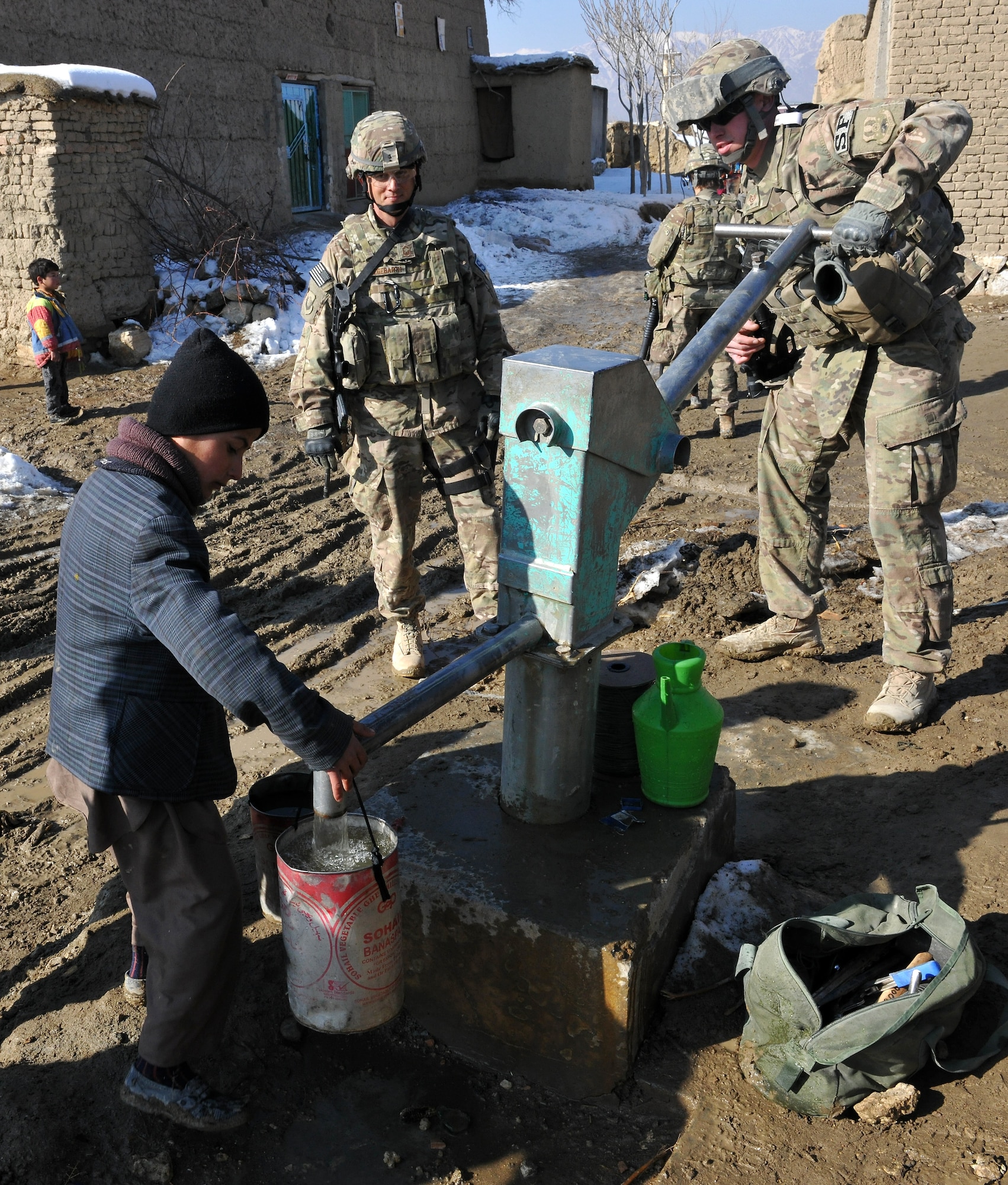 U.S. Airmen and local Afghan children pump water from the recently fixed water well located in a village near Bagram Airfield, Afghanistan, Jan. 26, 2013. The Airmen teamed up with local Afghan leaders to fix the broken well and bring the fresh groundwater back to the village. (U.S. Air Force photo/Senior Airman Chris Willis)
