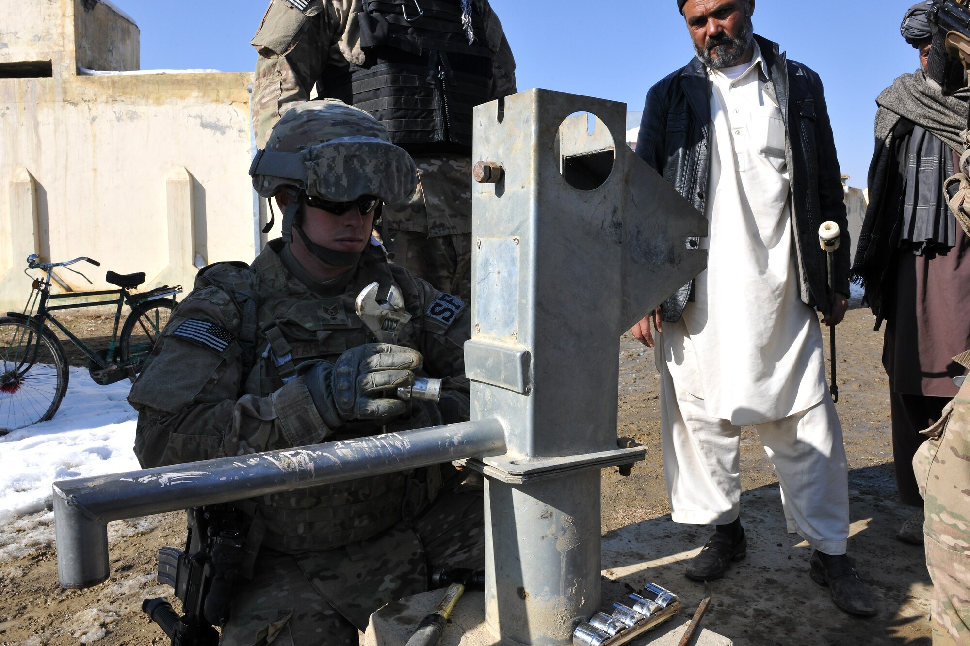 Members of the 777th Expeditionary Prime BEEF Squadron and the 755th Expeditionary Security Forces Squadron work on a broken water well located in a village near Bagram Airfield, Afghanistan, Jan. 26, 2013. Most of the local villages’ water well problems can be solved with a simple repair, cleaning, or redevelopment. (U.S. Air Force photo/Senior Airman Chris Willis)
