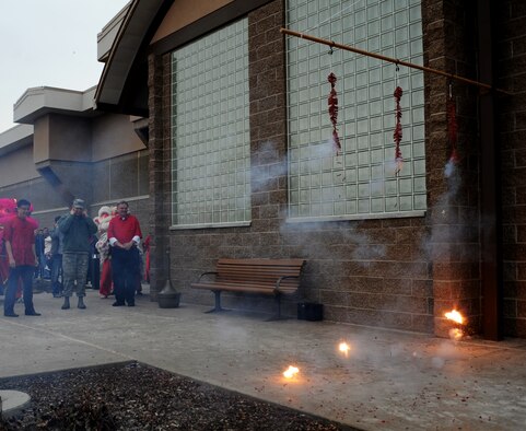 From left, Republic of Singapore Air Force Lt. Col. Jin Kiat Tan, 428th Fighter Squadron senior ranking officer, U.S. Air Force Col. Chris Short, 366th Fighter Wing commander, and Mr. Tom Rist, mayor of Mountain Home, Idaho, watch while fireworks explode signifying the start of the 428th FS Chinese New Year celebration Feb. 7, 2013, at Mountain Home Air Force Base, Idaho. The celebration was held inside the ballroom of the Gunfighter Service Center to accommodate the more than 300 personnel in attendance. (U.S. Air Force photo/Senior Airman Benjamin Sutton)