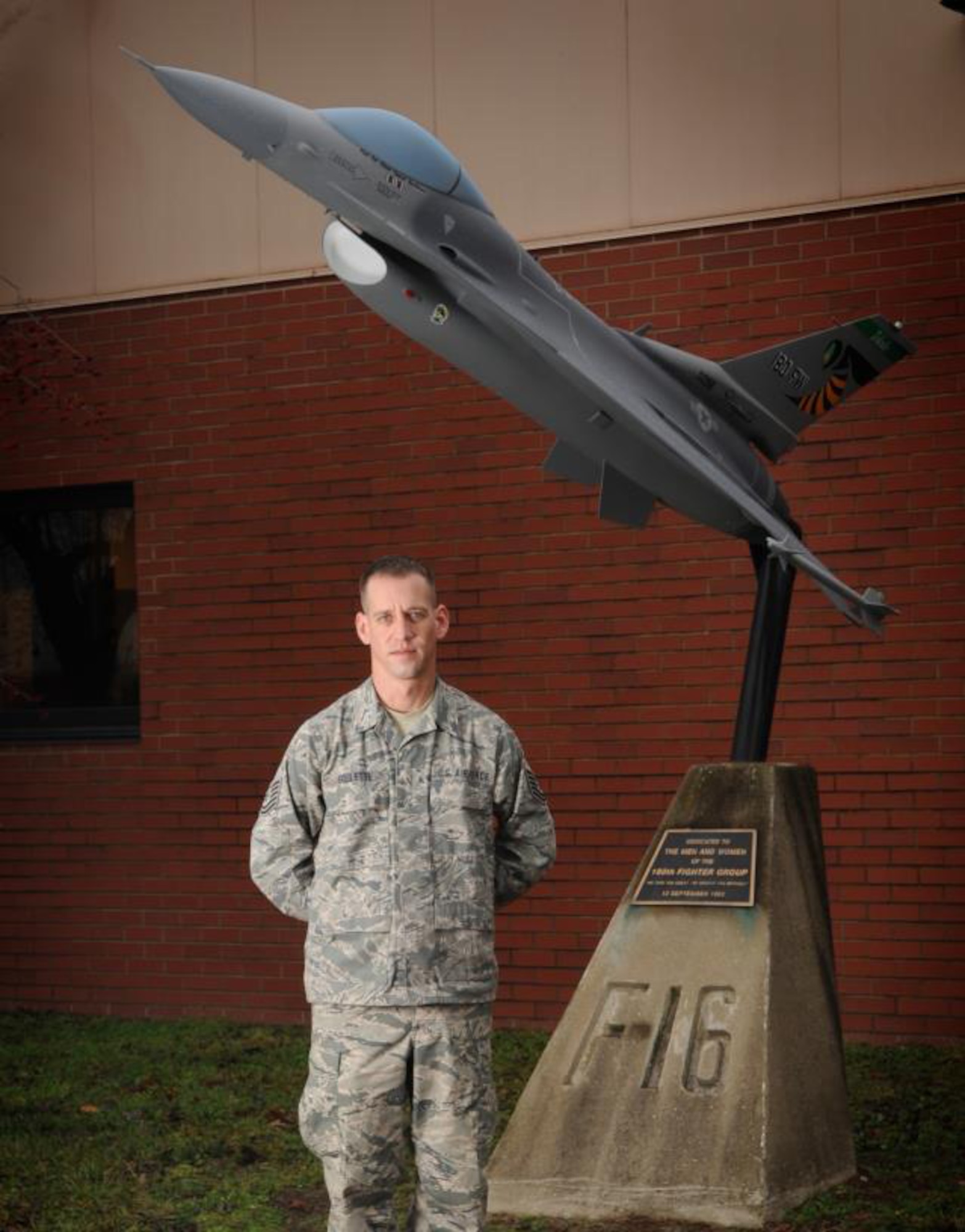 Tech. Sgt. Michael Goulette, a structural repair specialist with the 180th Fighter Wing, Ohio Air National Guard, with the F-16 static display in front of the 180th Fighter Wing Operations building.