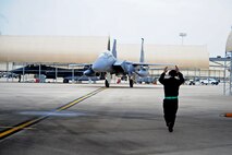 U.S. Air Force Airman 1st Class Dustin Bishop, 4th Aircraft Maintenance Squadron crew chief, signals for an F-15E Strike Eagle to taxi into an aircraft shelter during Exercise RAZOR TALON on Seymour Johnson Air Force Base, N.C., Feb. 7, 2013. RAZOR TALON is a monthly Atlantic Coast large-force exercise and joint-unit training opportunity that employs cutting edge operational concepts such as AirSea Battle and Maritime Air Support. (U.S. Air Force photo/Airman 1st Class Aubrey White/Released)