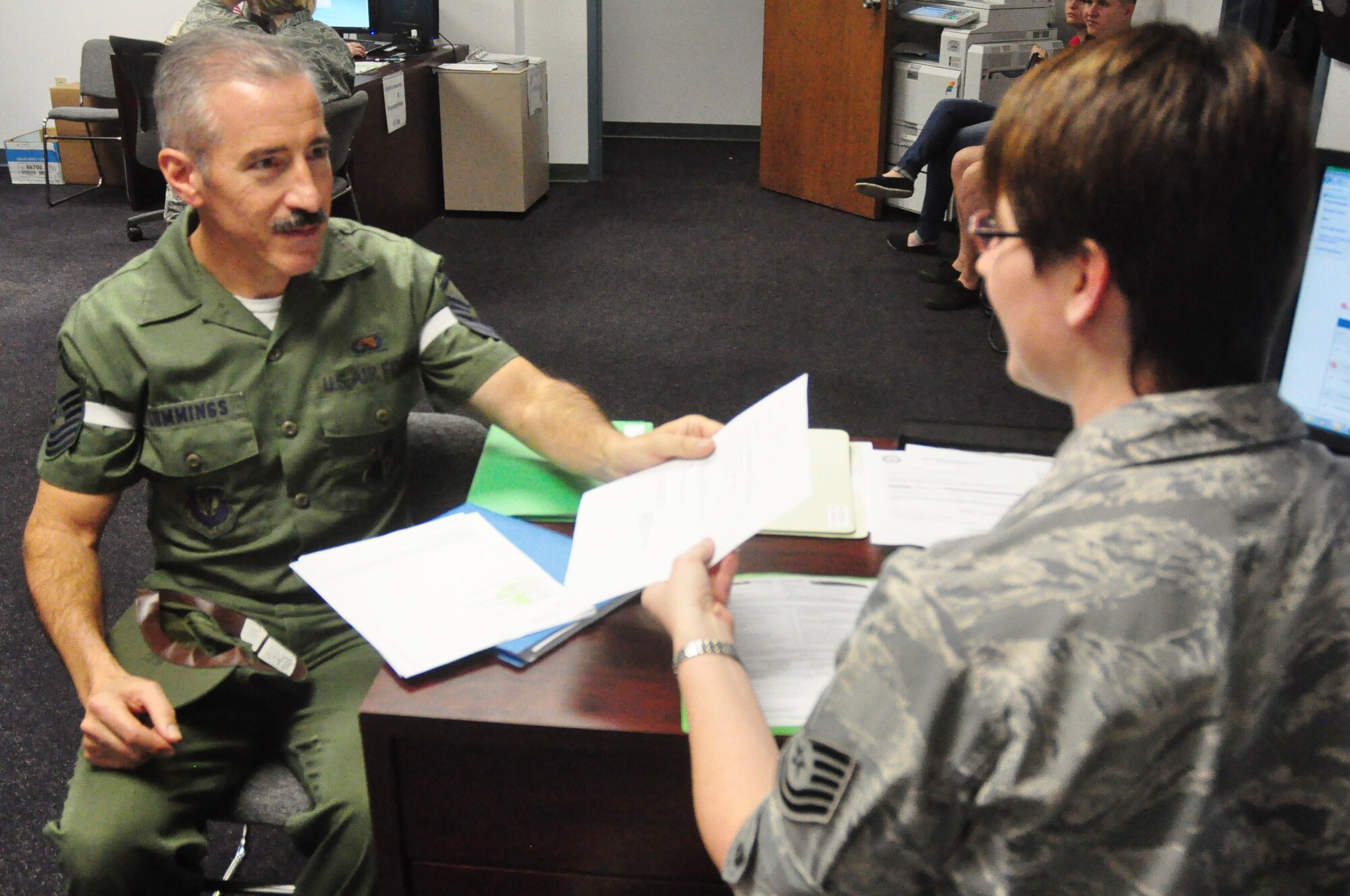 Senior Master Sgt. Henry Cummings, 325th Aircraft Maintenance Squadron lead production superintendent, completes his retirement outprocessing paperwork in his basic training-issued uniform from April 1987. Sergeant Cummings will retire with 26 years of service to the U.S. Air Force. “I wanted to go out the way I came in,” he said. “This is my way of paying tribute to a proud heritage and all the effort I put into my career.” He also added that no dieting was necessary for him to fit back into his original uniform. (U.S. Air Force photo by Staff Sgt. Rachelle Elsea)