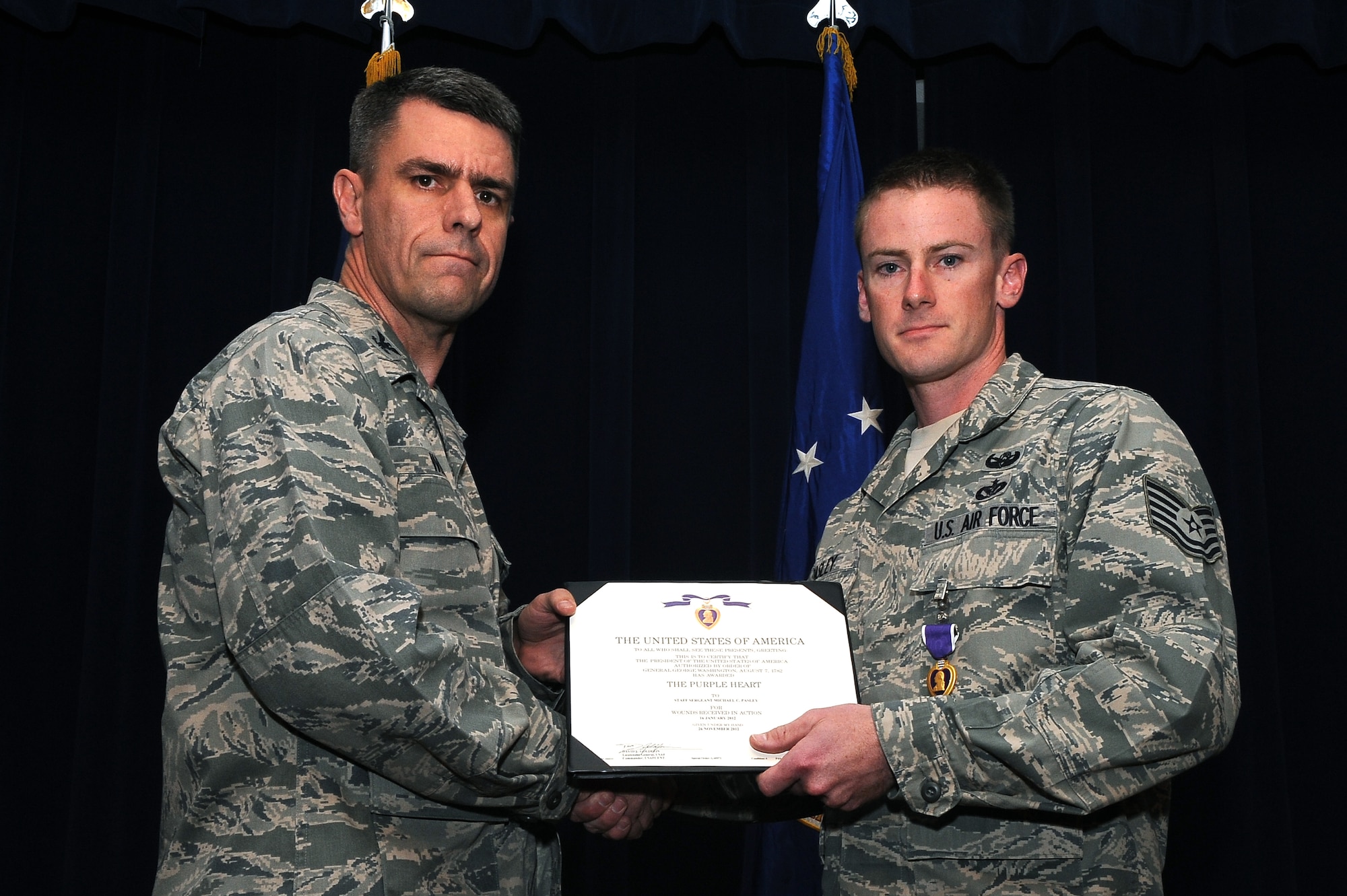 Tech. Sgt. Michael Pasley, 56th Civil Engineer Squadron Explosive Ordnance Disposal utilities superintendent, receives a Purple Heart at Luke Air Force Base Jan. 31. He received the award for when an improvised explosive device hit his vehicle injuring him during a deployment to Afghanistan January 2012. (U.S. Air Force photo/Airman 1st Class James Hensley)