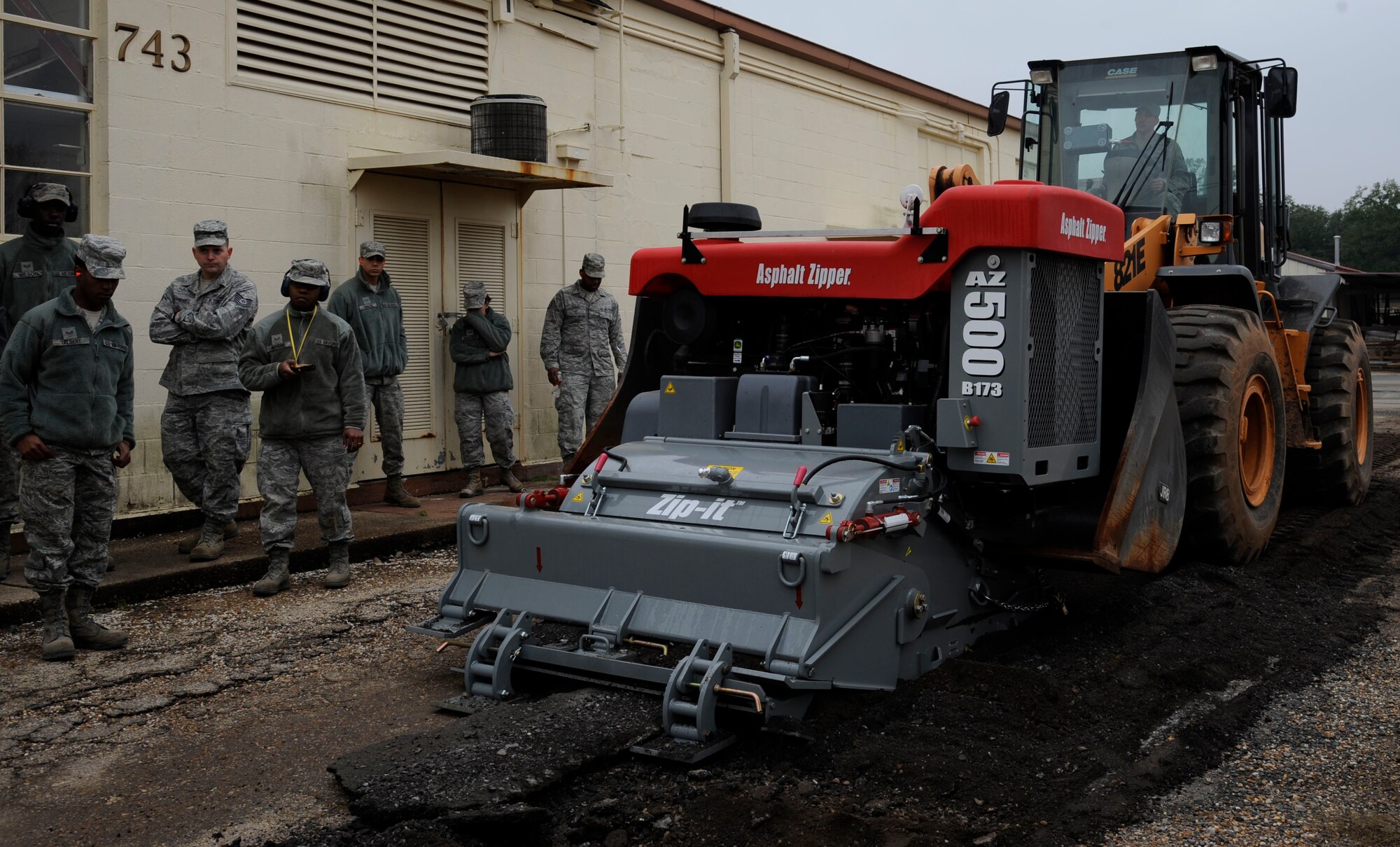 Airmen assigned to the 2nd Civil Engineer Squadron heavy repair section, watch Airman 1st Class Cameron Kruell, 2 CES heavy repair, demonstrate the Asphalt Zipper on Barksdale Air Force Base, La., Feb. 6.  The heavy repair section, also known as the "Dirt Boys", received the new piece of equipment in order to help them do their job of installing fencing and repairing pavement more efficiently. (U.S. Air Force photo/Airman 1st Class Andrew Moua)