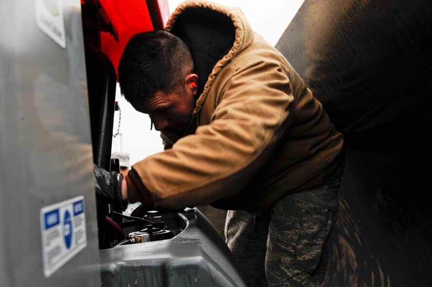 Airman 1st Class Ali Trincado, 2nd Civil Engineer Squadron heavy repair section, hooks up power cables to a machine known as an Asphalt Zipper on Barksdale Air Force Base, La., Feb. 6. The Asphalt Zipper grinds down old pavement which allows repairs to be done more easily by providing an even base for new asphalt to be laid. (U.S. Air Force photo/Airman 1st Class Andrew Moua)