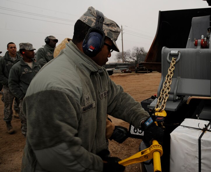 Senior Airman Christopher Mahone, 2nd Civil Engineer Squadron heavy repair section, unhooks an Asphalt Zipper on Barksdale Air Force Base, La., Feb. 6. The heavy repair section, also known as the "Dirt Boys", received the new piece of equipment in order to help them do their job of installing fencing and repairing pavement more efficiently. (U.S. Air Force photo/Airman 1st Class Andrew Moua)