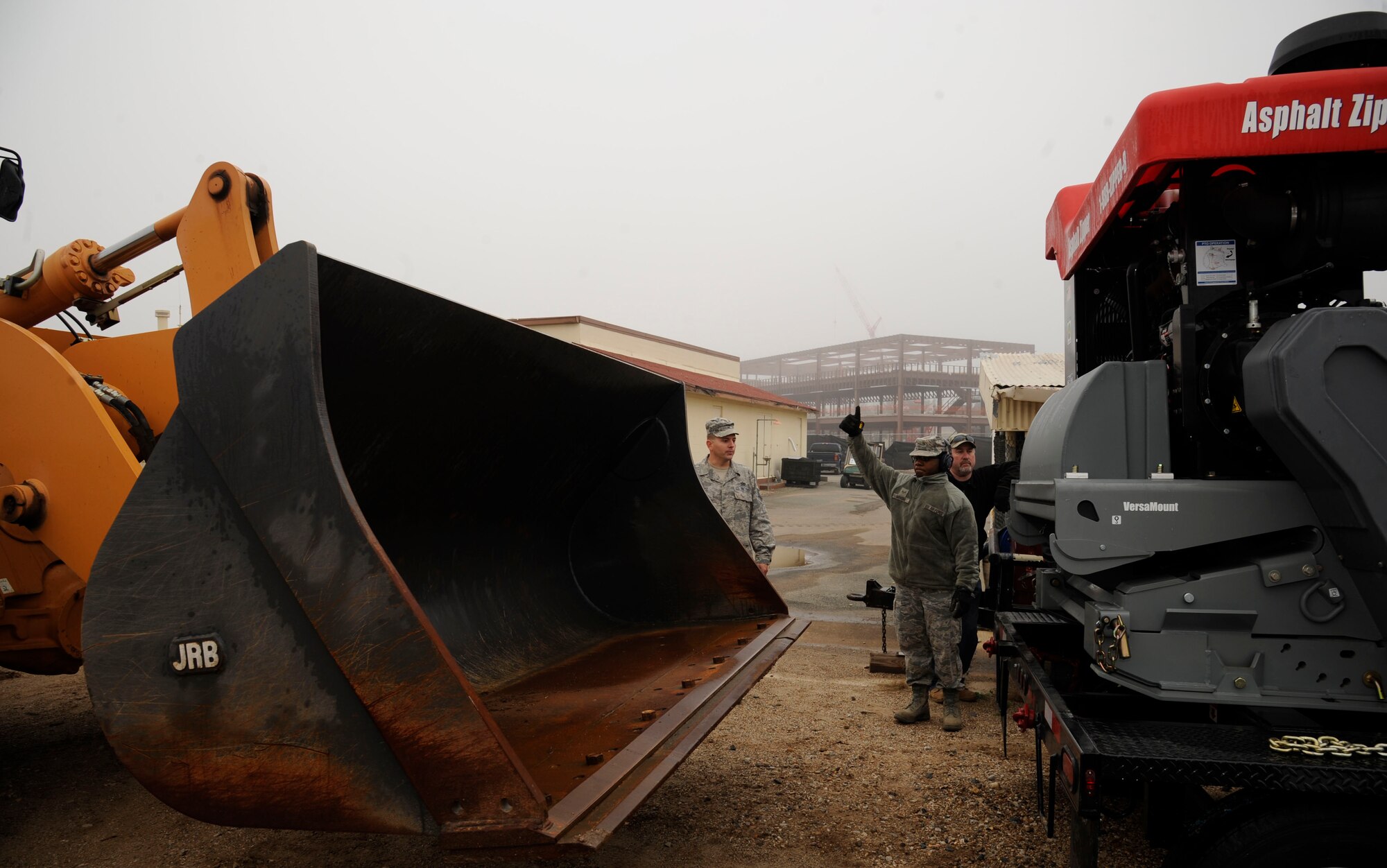 Senior Airman Christopher Mahone, 2nd Civil Engineer Squadron heavy repair section, guides a loader to pick up an Asphalt Zipper on Barksdale Air Force Base, La., Feb. 6. One of the responsibilities of the heavy repair section, also known as the "Dirt Boys", is pavement repair and installation. The Asphalt Zipper will enable them to tear down and set up new pavement more efficiently. (U.S. Air Force photo/Airman 1st Class Andrew Moua)