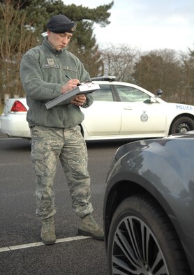 Senior Airman Oleksandr Martynyuk, 100th Security Forces Squadron response force leader from Ternopil, Ukraine, cites a vehicle for a parking violation Feb. 7, 2013, on RAF Mildenhall, England. (U.S. Air Force photo by Airman 1st Class Dillon Johnston/Released)