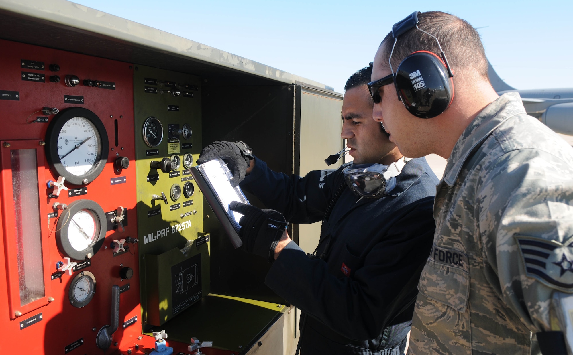 Tech. Sgt. Richard Mora (left) and Staff Sgt. Nahim Alhamdan, 100th Aircraft Maintenance Squadron, go over the plan to lift a KC-135 Stratotanker on hydraulic jacks Feb. 5, 2013, at an air base in southwest Europe. Jacks allow maintainers to conduct tests involving raising and lowering the aircraft’s landing gear. Airmen from RAF Mildenhall, England, deployed to southwest Europe in January to support French operations in Mali. Mora is from San Diego, and Alhamdan is from Tacoma, Wash. (U.S. Air Force photo by Staff Sgt. Austin M. May)