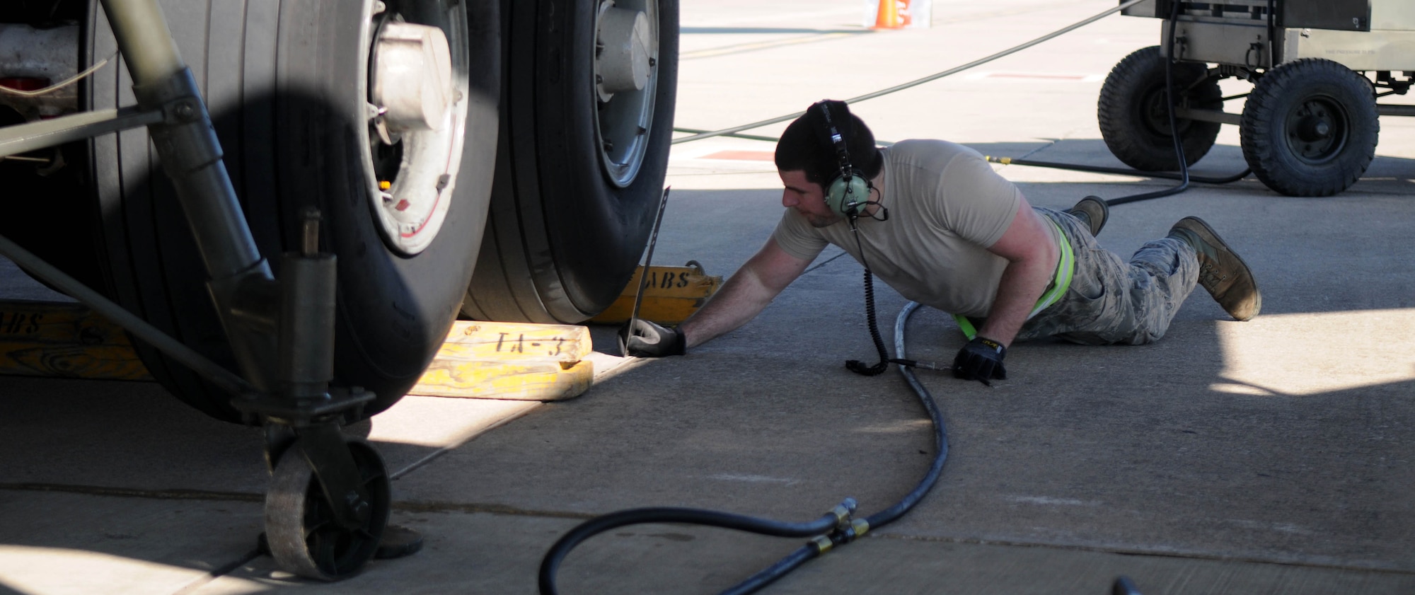 Staff Sgt. Nicholas Carone, 100th Aircraft Maintenance Squadron, measures the distance between the ground and the tires of a KC-135 Stratotanker being lifted on hydraulic jacks Feb. 5, 2013, at an air base in southwest Europe. The aircraft tires had to be a certain distance off the ground to allow for the raising and lowering of the landing gear. Airmen from RAF Mildenhall, England, deployed to southwest Europe in January to support French operations in Mali. Carone is from Elk Grove, Calif. (U.S. Air Force photo by Staff Sgt. Austin M. May)