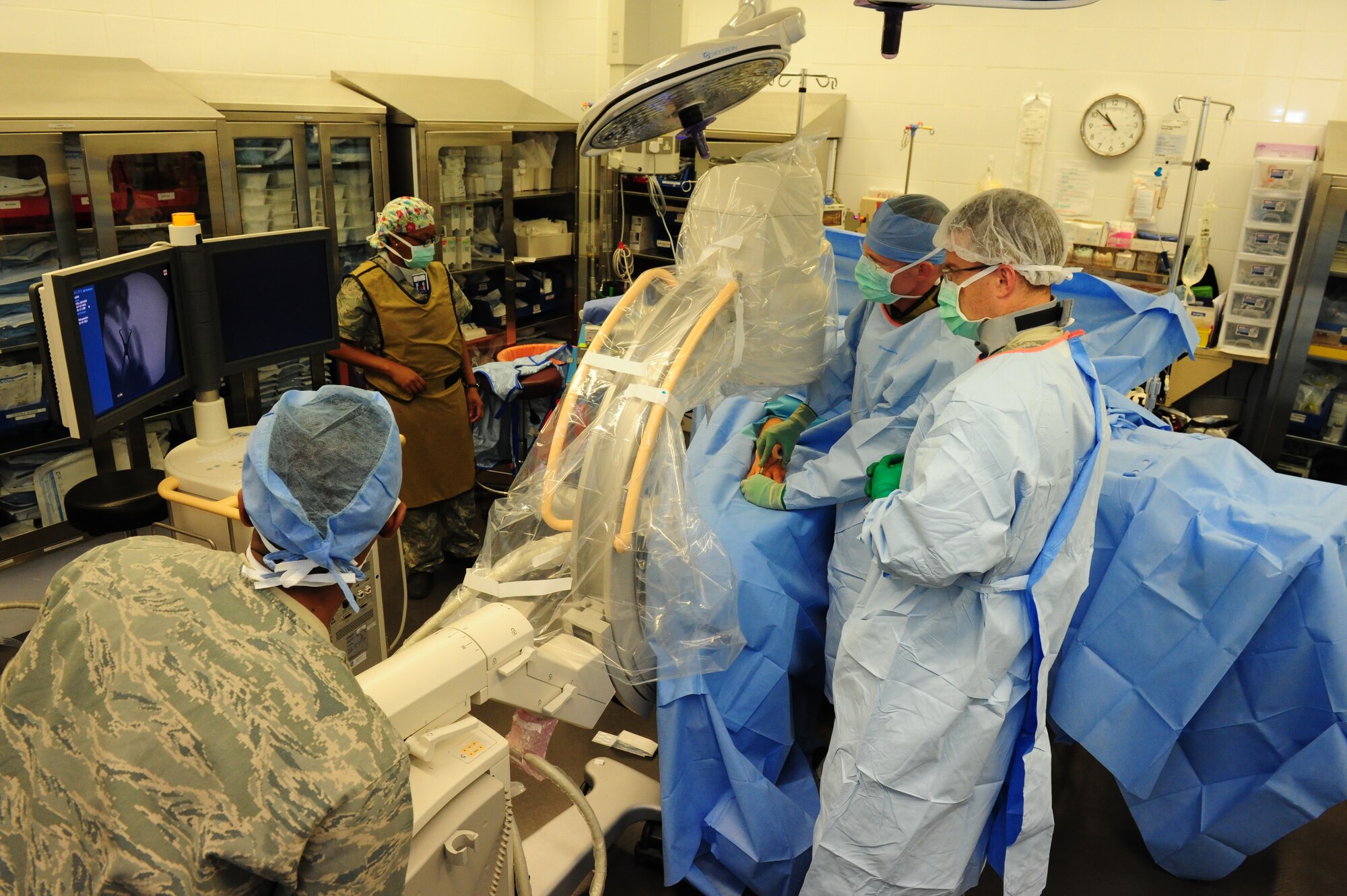 SOUTHWEST ASIA – The operating room team uses a C-arm fluoroscopy, which uses X-rays to obtain real-time moving images of the patient so the surgeon can see where he is setting his pins Feb. 7. The patient’s hand was fractured requiring the OR team to set pins to align the fractured bones.  (U.S. Air Force photo/Master Sgt. Brendan Kavanaugh)