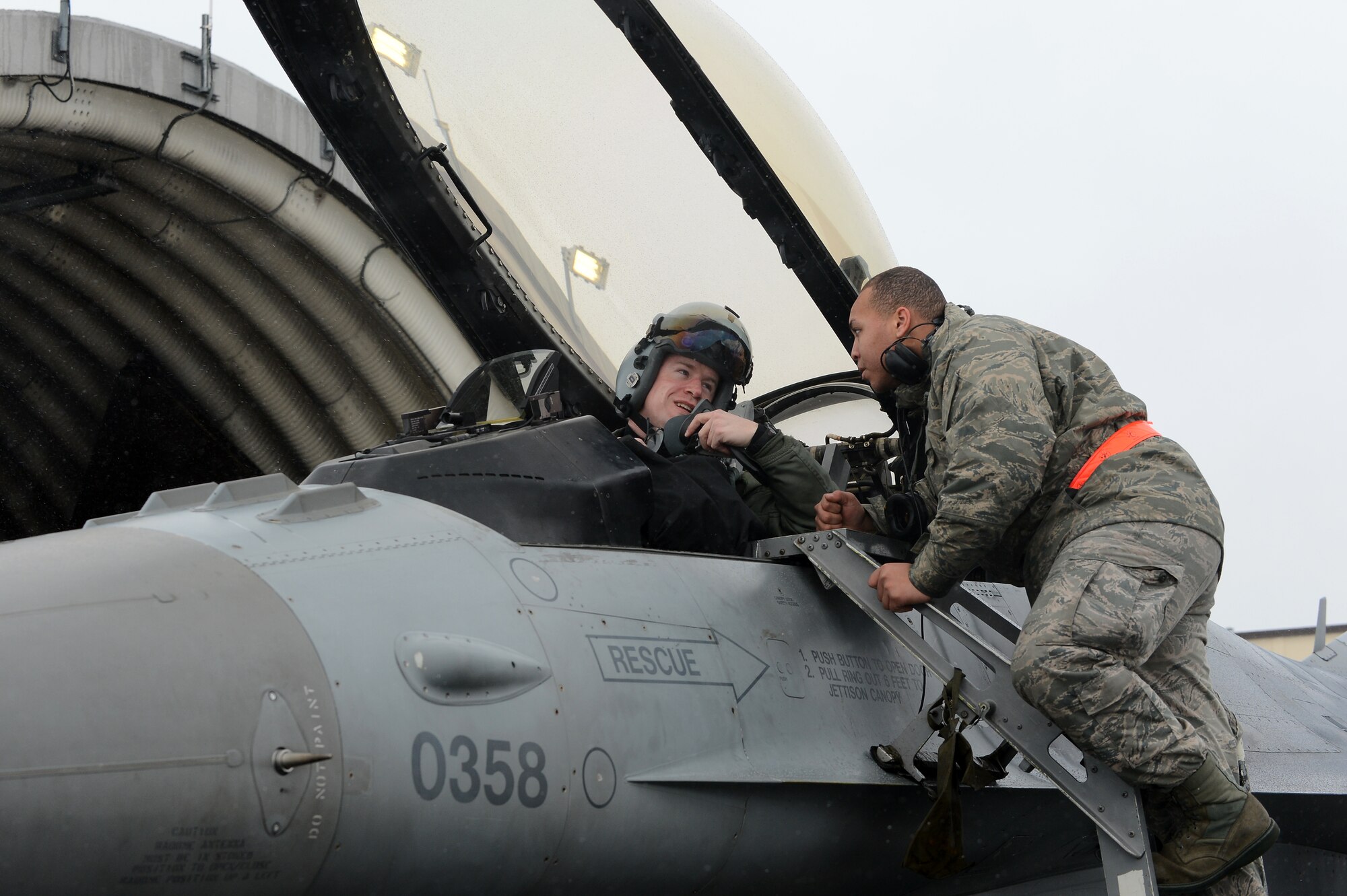 SPANGDAHLEM AIR BASE, Germany – U.S. Air Force Senior Airman Samuel Leach, right, 52nd Equipment Maintenance Squadron phase inspection crew chief, helps U.S. Air Force Major Michael Anderson, 480th Fighter Squadron pilot, exit an F-16 Fighting Falcon after returning from Red Flag Feb. 6, 2013. Anderson participated in Red Flag along with other pilots from across the Air Force to prepare for upcoming deployments. (U.S. Air Force photo by Senior Airman Dillon Davis/Released)