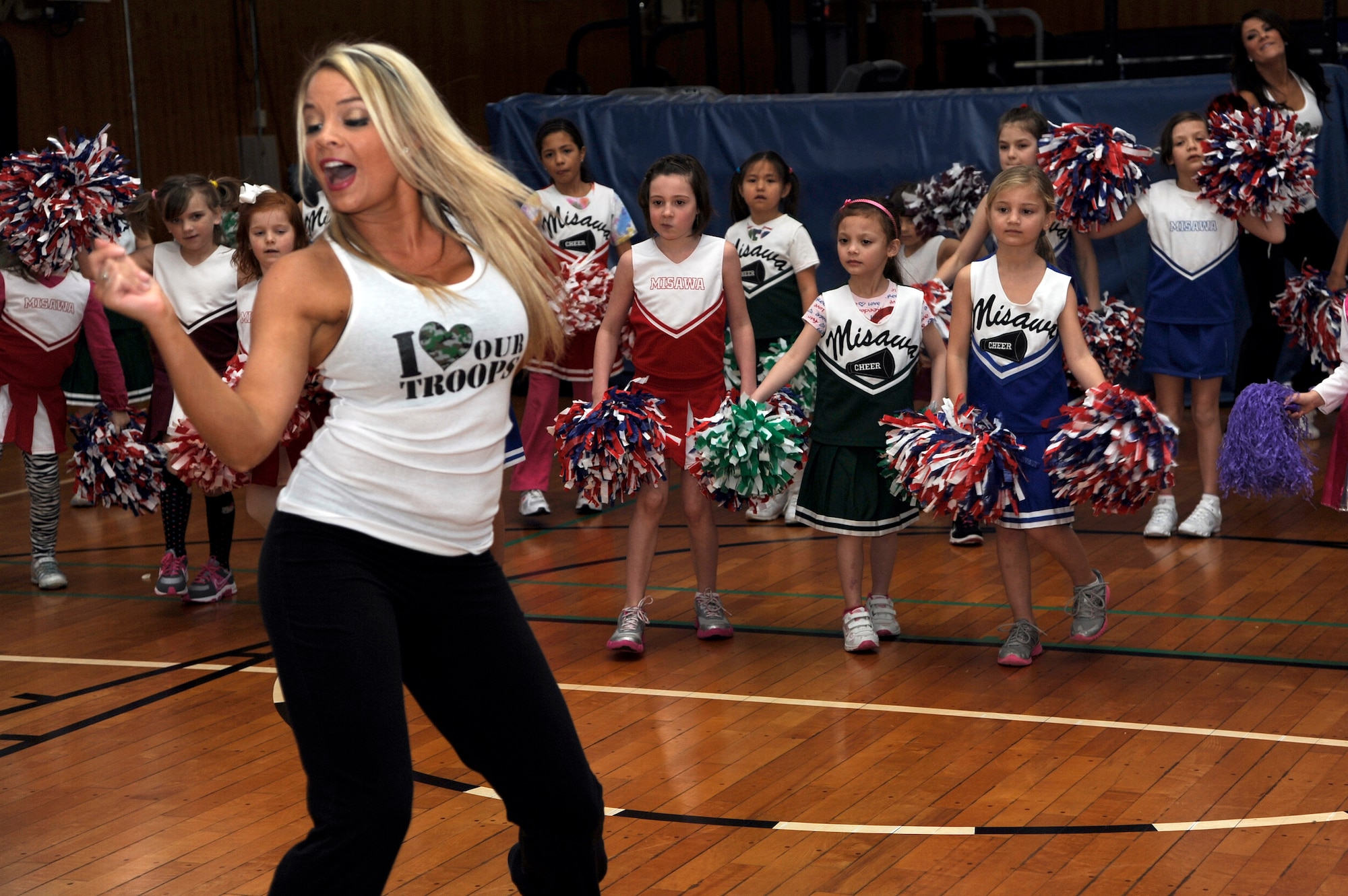 Lauren, Tampa Bay Buccaneers cheerleader, teaches Misawa youth a couple moves at a cheer clinic on Misawa Air Base, Japan, Feb. 4, 2013. Lauren, along with the other three National Football League stars, came to Misawa to show their appreciation for what service members at Misawa do on a daily basis. (U.S. Air Force photo by Tech. Sgt. Marie Brown)