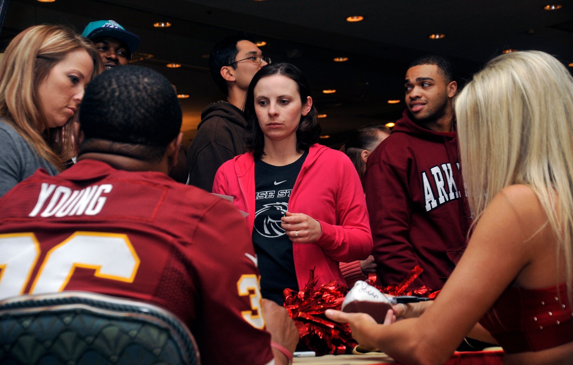 Darrel Young, left, Washington Redskins fullback, and Lauren, Tampa Bay Buccaneers cheerleader, sign autographs for members of the base community at Misawa Air Base, Japan, Feb. 5, 2013. Young, along with three other NFL stars, came to Misawa to show their appreciation for what service members do on a daily basis. (U.S. Air Force photo by Airman 1st Class Zachary Kee)