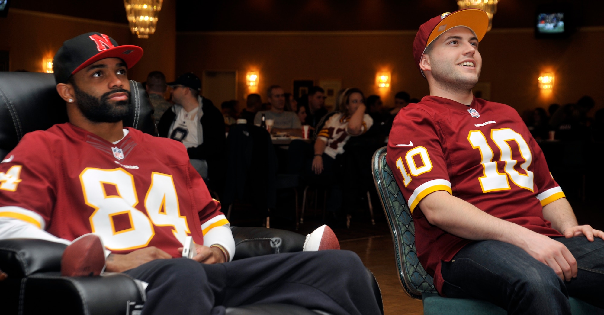 Niles Paul, left, Washington Redskins tight end, watches the Super Bowl with Senior Airman Keegan Early, 35th Maintenance Operations Squadron maintenance planning, scheduling and documentation, at the Misawa Club Complex on Misawa Air Base, Japan, Feb. 5, 2013. Paul and the rest of the NFL stars came to Misawa to show their appreciation for what service members do on a daily basis.  (U.S. Air Force photo by Airman 1st Class Zachary Kee)