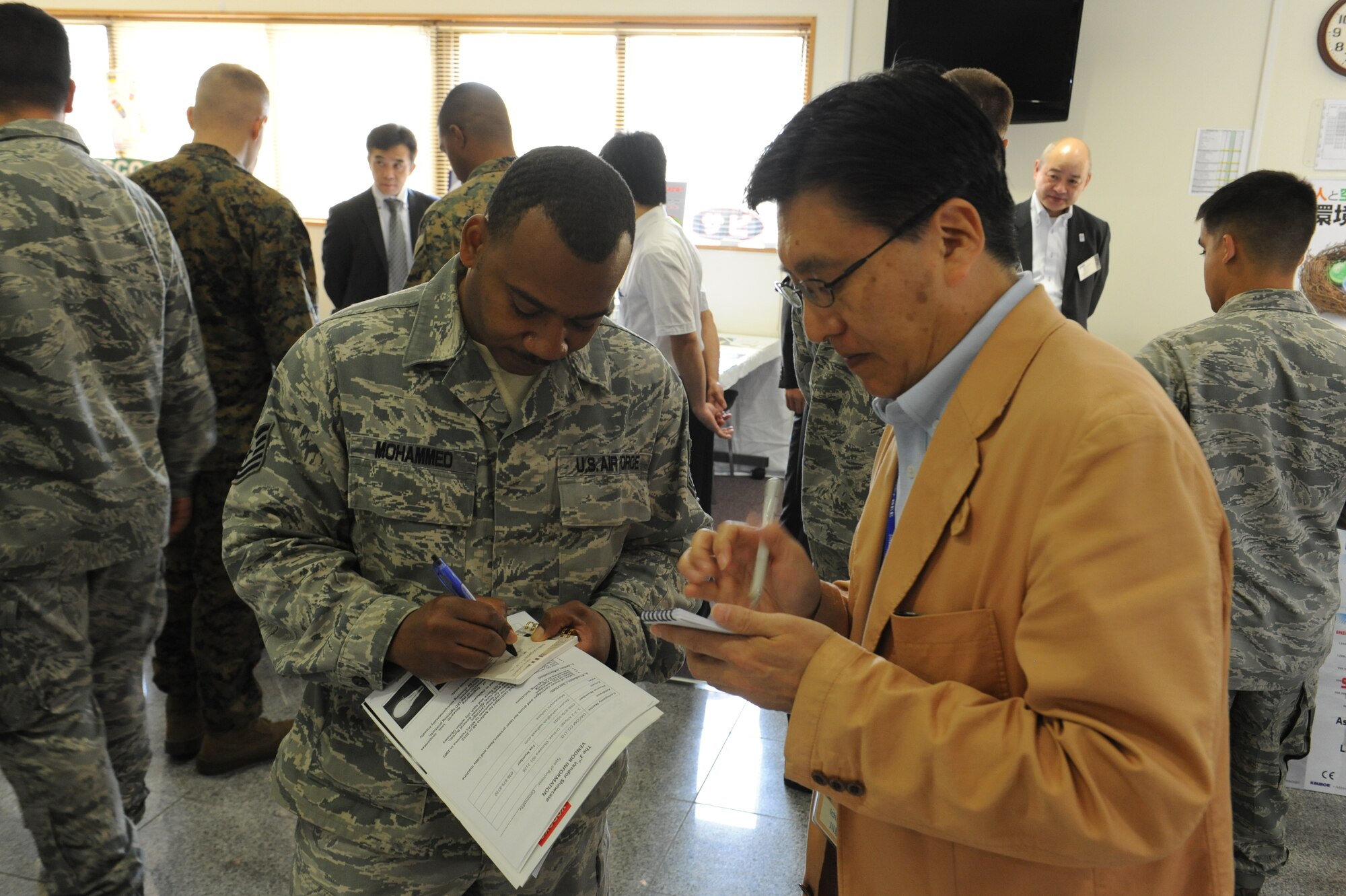 U.S. Air Force Tech. Sgt. Marvin Mohammed, 18th Logistics Readiness Squadron NCO in charge of cryogenic production, exchanges information with Ichiro Kawai, a Shibuya-Giken member, at the third-annual Okinawan first vendor showcase on Kadena Air Base, Japan, Feb. 7, 2013. The showcase gave military members a chance to interact with local businesses and seek opportunities to conduct business with our host nation. (U.S. Air Force photo/Airman 1st Class Malia Jenkins)