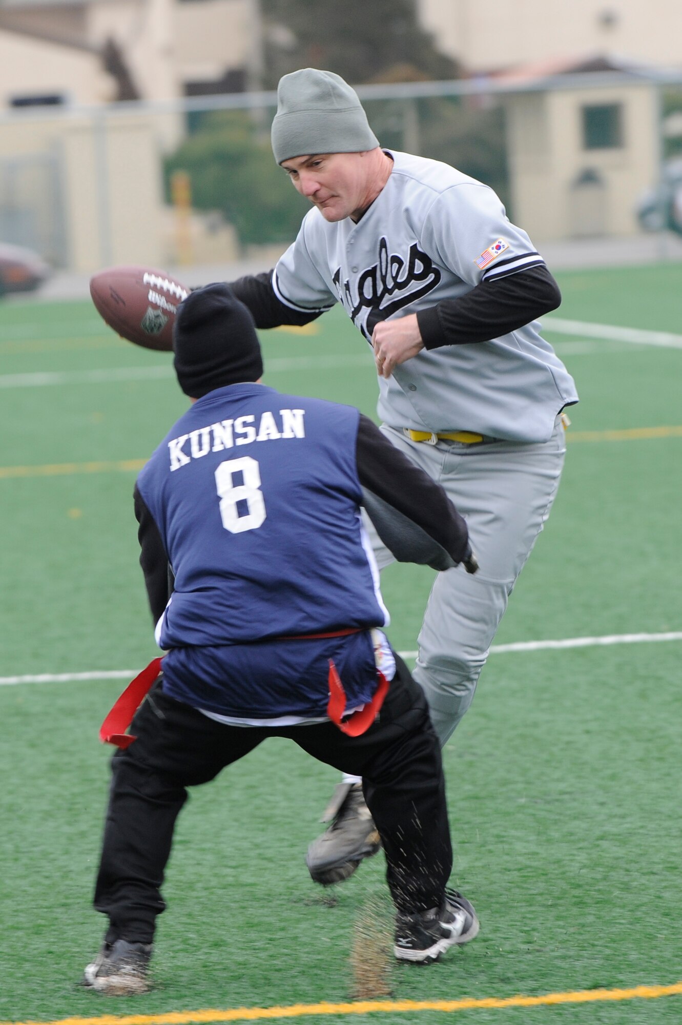 Col. John Pearse, 8th Fighter Wing commander jukes Chief Master Sgt. Michael Faccenda, 8th Logistics Readiness Squadron, during the Chiefs and Eagles flag football game at Kunsan Air Base, Republic of Korea, Feb. 3, 2013.  Pearse assisted his team in getting within scoring distance during his run. (U.S. Air Force photo by Senior Airman Marcus Morris/Released)