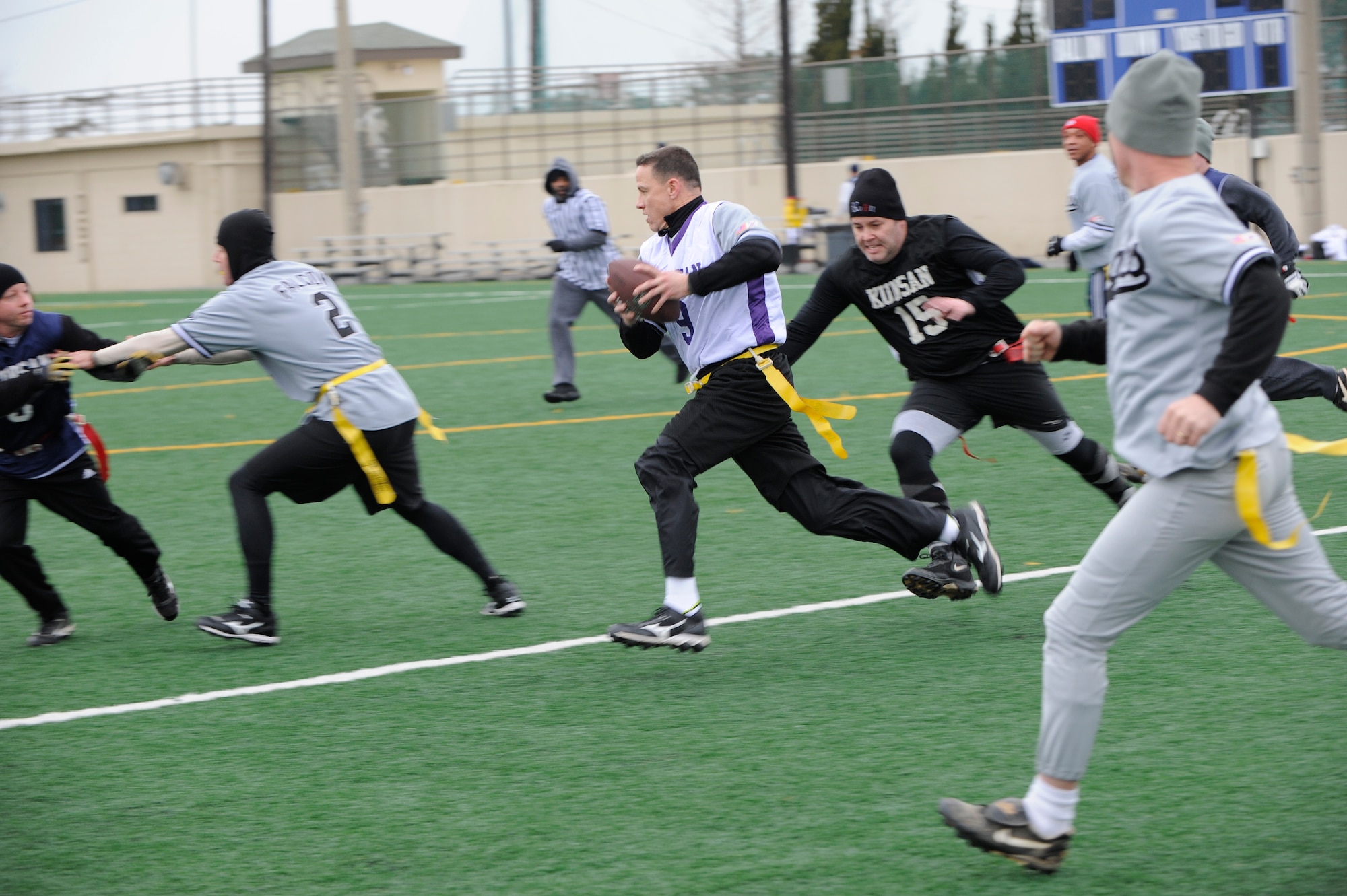 Col. James Sturgeon, middle, 8th Operations Group commander, runs down the field as Chief Master Sgt. Robert Wydler, right, 8th Maintenance Group, tries to remove Sturgeon’s flag during the Chiefs and Eagles flag football game at Kunsan Air Base, Republic of Korea, Feb. 3, 2013. Sturgeon scored two touchdowns for his team. (U.S. Air Force photo by Senior Airman Marcus Morris/Released)