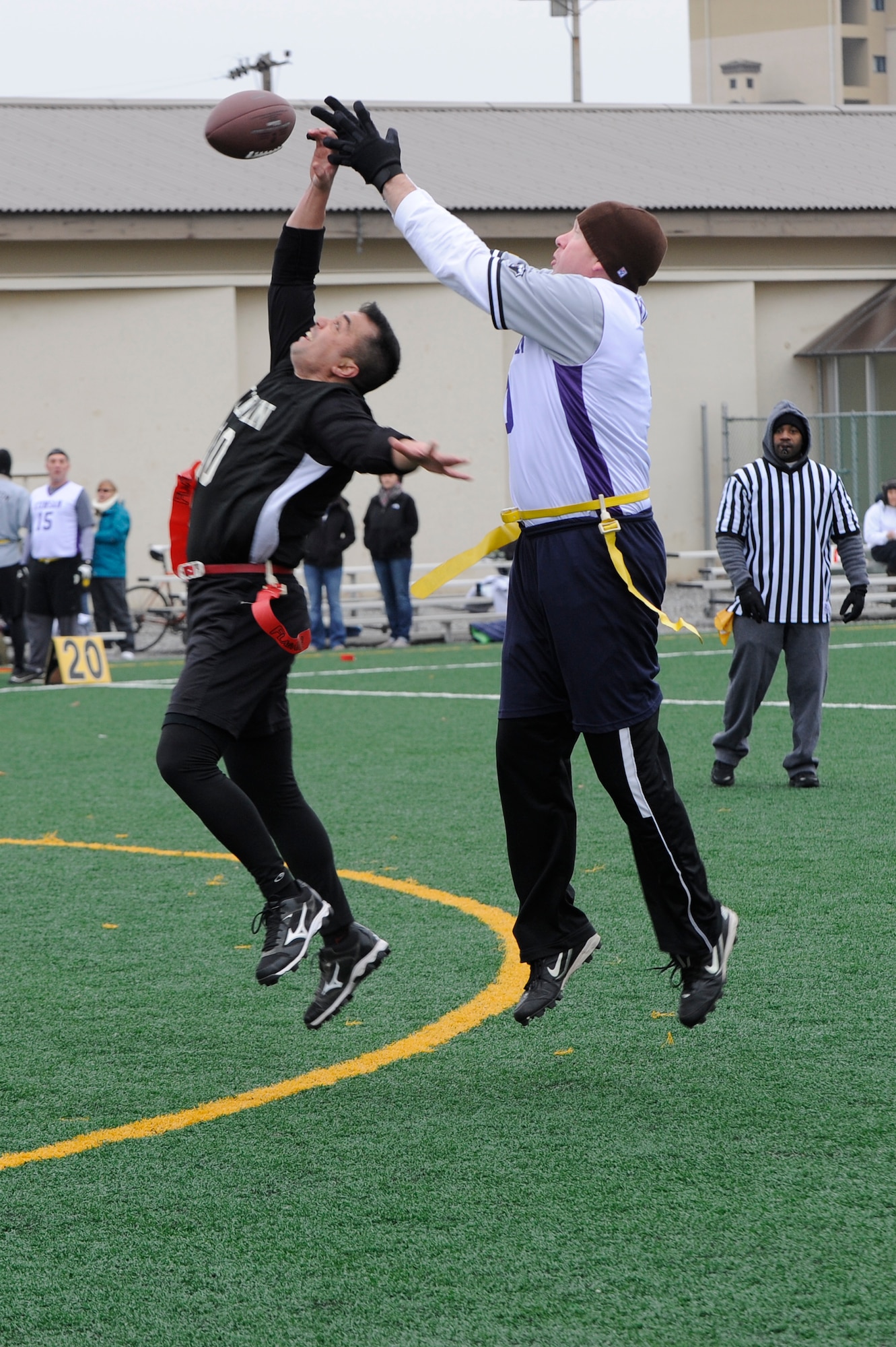 Chief Master Sgt. Jeffery Vallery, 8th Security Forces Squadron, left reaches out to catch the football as Lt. Col. Michael Miles, 8th Maintenance Group deputy commander tries to intercept, during the Chiefs and Eagles flag football game at Kunsan Air Base, Republic of Korea, Feb. 3, 2013. The Eagles beat the Chiefs 24-0. (U.S. Air Force photo by Senior Airman Marcus Morris/Released)