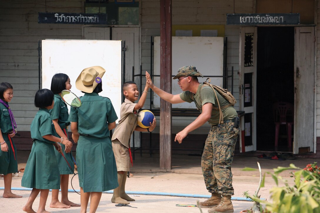 Niti Soonkoontod high-fives U.S. Marine Lance Cpl. Cuang V. Cao during their lunch break Jan. 24 at Chat Trakarn district, Phitsanulok province, Kingdom of Thailand. Cao is a combat engineer with 9th Engineer Support Battalion, 3rd Marine Logistics Group, III Marine Expeditionary Force.  Soonkoontod is a 12-year-old student of the Ban Kuad Nam Man School.