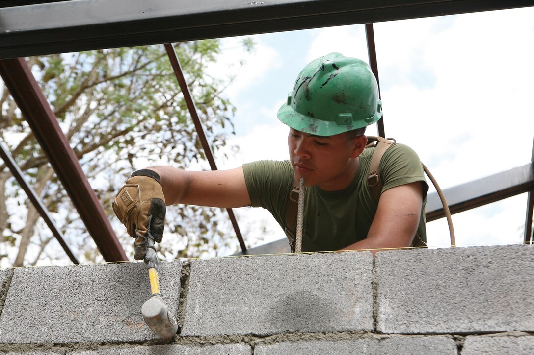 Lance Cpl. Cuang V. Cao aligns a cement cinder block wall Feb. 1 during the construction of a new building at Ban Kuad Nam Man School, Chat Trakarn district, Phitsanulok province, Kingdom of Thailand, as part of an ongoing engineering civic action project. Cao is a combat engineer with 9th ESB.
