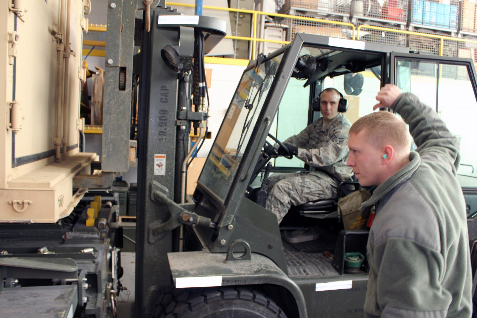 Staff Sgt. Jason Bucholtz keeps close watch on Technical Sgt. Rodger Zink, both of the 127th Logistics Readiness Squadron, as the two Airmen move an ISU-70 shipping container off a K-loader during cargo operations at Selfridge Air National Guard Base, Mich., Feb. 9, 2013. As a member of the Aerial Port at the base, Bucholtz is charged with the safe and efficient movement of cargo and personnel on military aircraft. (Air National Guard photo by TSgt. Dan Heaton)
