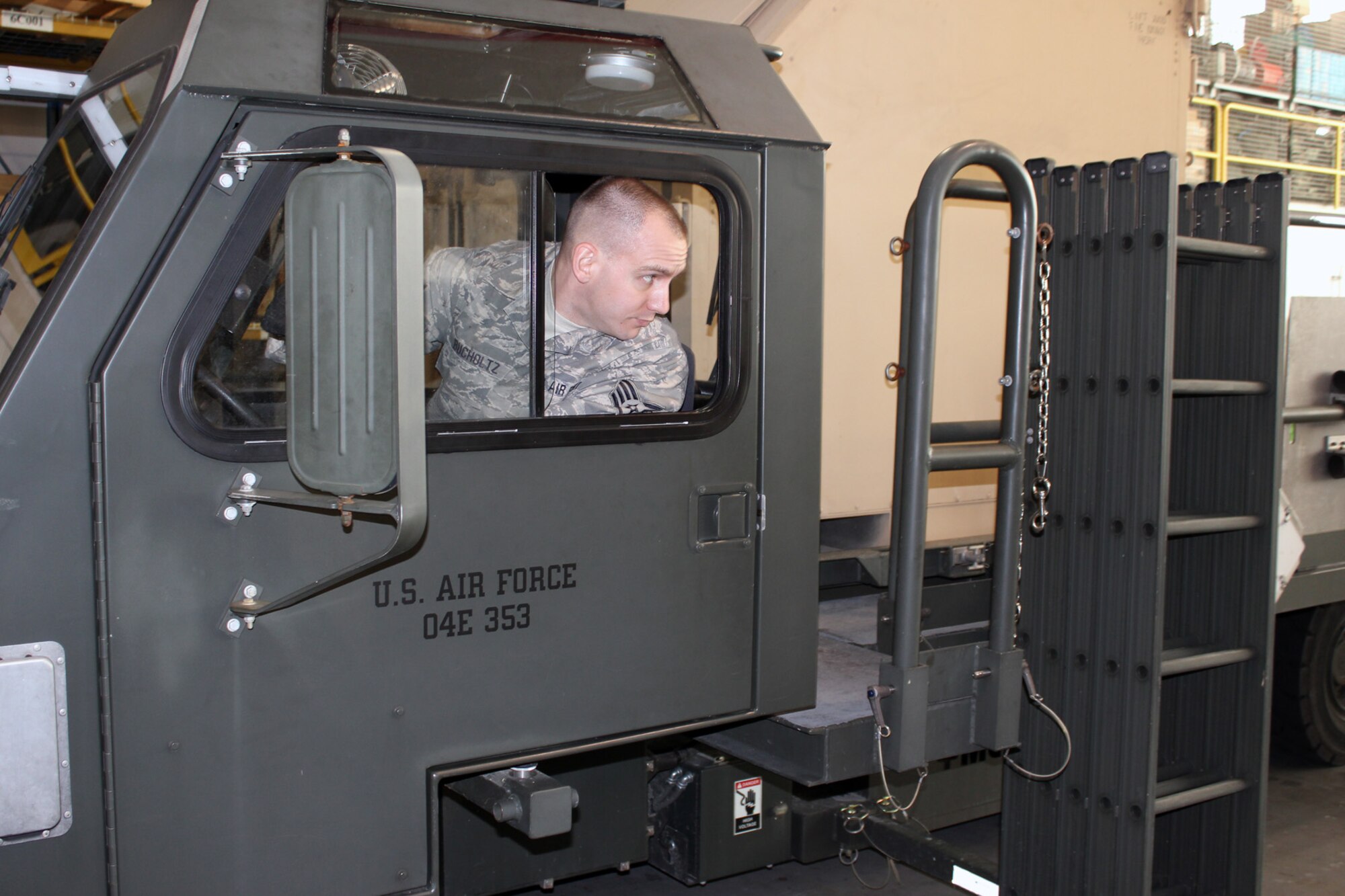 Staff Sgt. Jason Bucholtz, 127th Logistics Readiness Squadron, looks back to his spotter, as he operates a K-loader at Selfridge Air National Guard Base, Mich., Feb. 9, 2013. As a member of the Aerial Port at the base, Bucholtz is charged with the safe and efficient movement of cargo and personnel on military aircraft. (Air National Guard photo by TSgt. Dan Heaton)